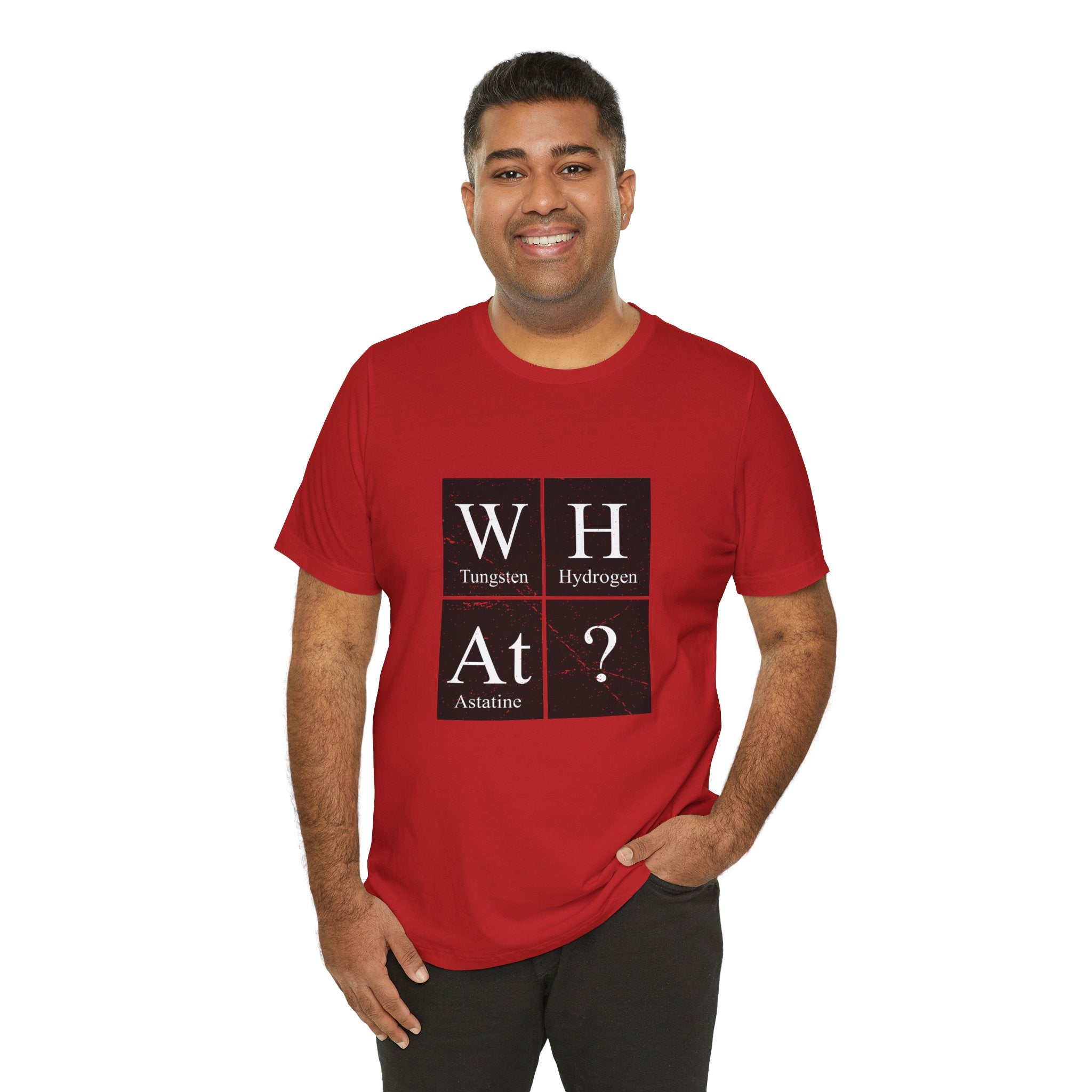 Man in a red unisex jersey tee with a W-H-At-? design smiling and standing against a white background.