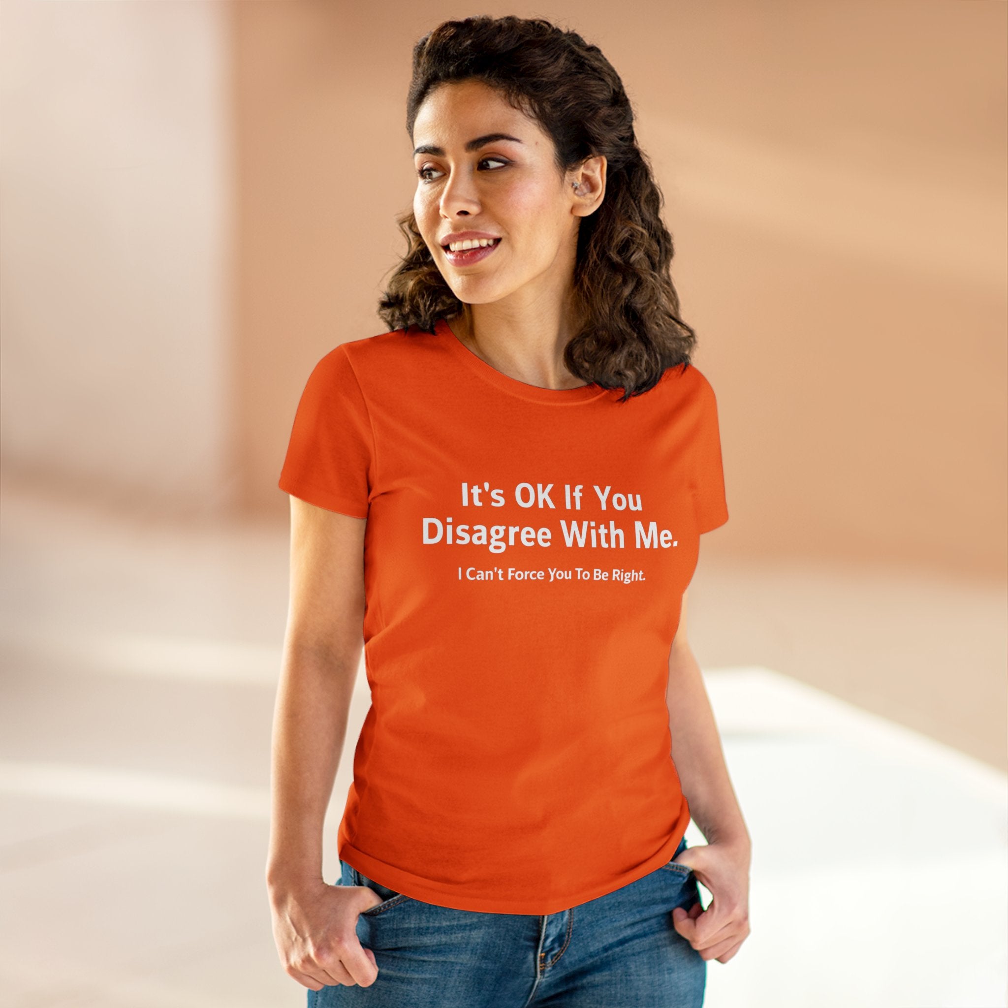 A person wearing a pre-shrunk orange It's Ok If You Disagree With Me - Women's Tee with the empowering print, "It's OK If You Disagree With Me. I Can't Force You To Be Right," standing in front of a plain background.