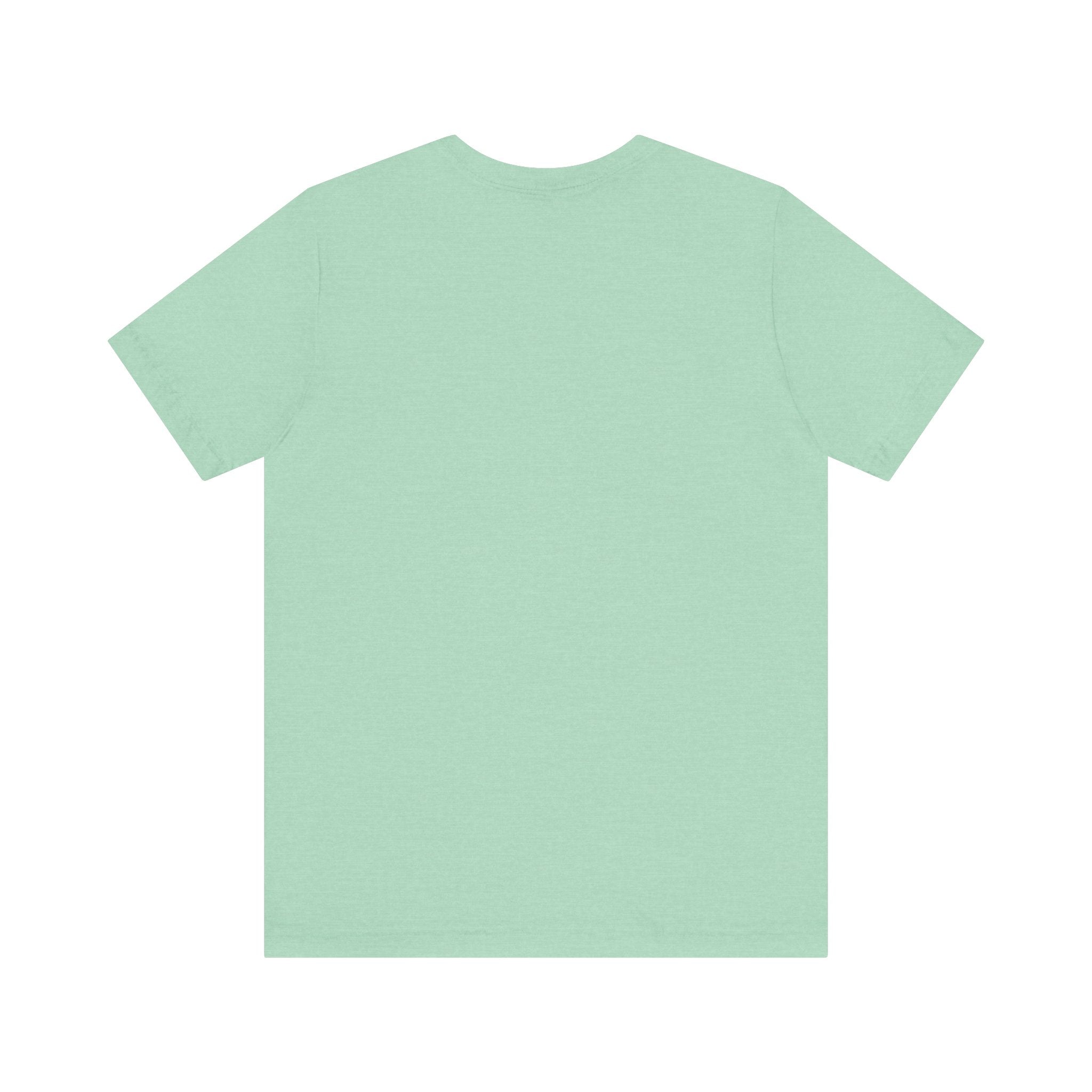 The "Cache Me in The Cloud - T-Shirt" is displayed flat with its back facing upward, revealing a pristine design-free surface. This light green t-shirt, made from soft Airlume cotton, combines comfort and style seamlessly.