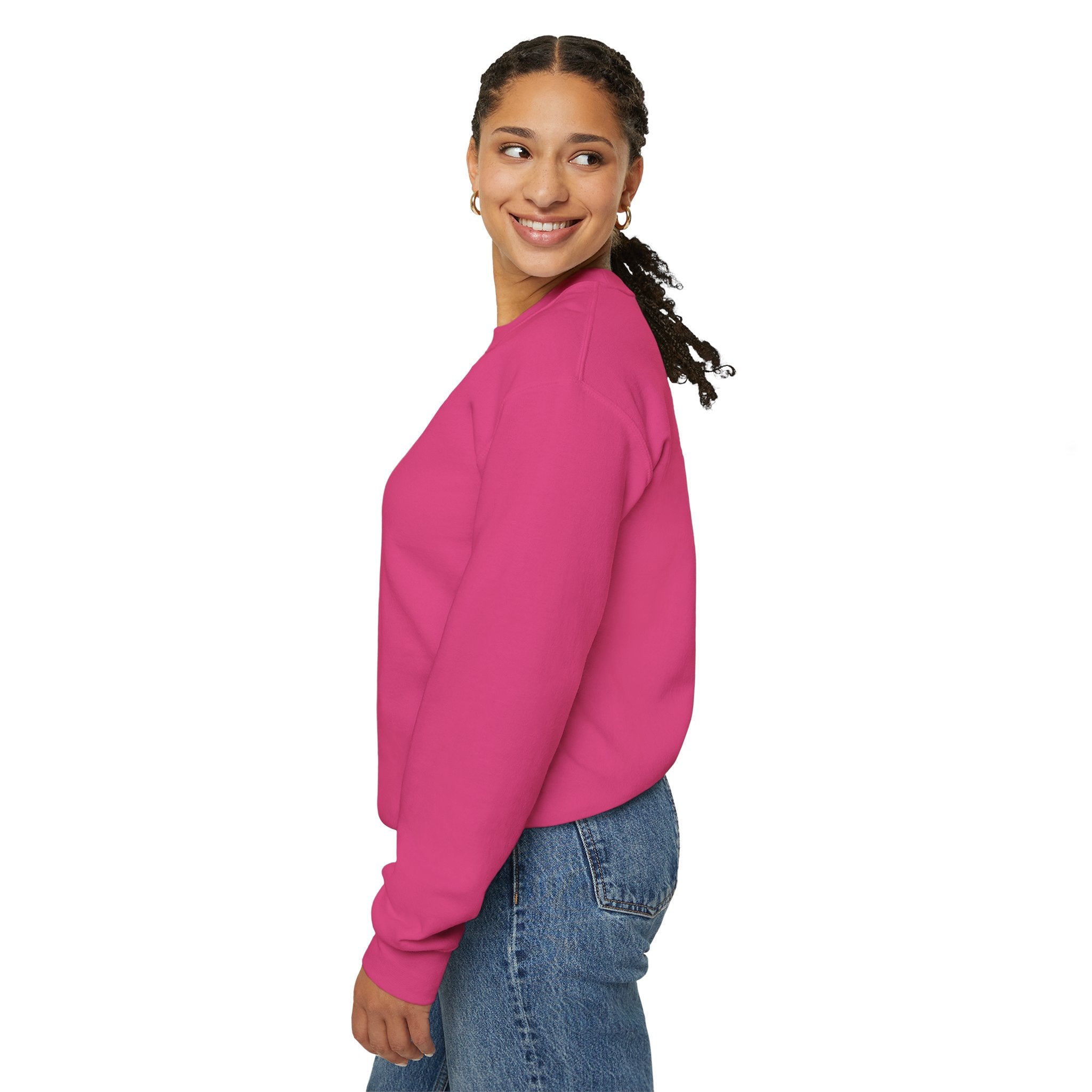 Wearing a vibrant pink "Deploy Now, Debug Later" sweatshirt paired with blue jeans, a person smiles and looks to the side against a plain white background, prepared for the colder months.