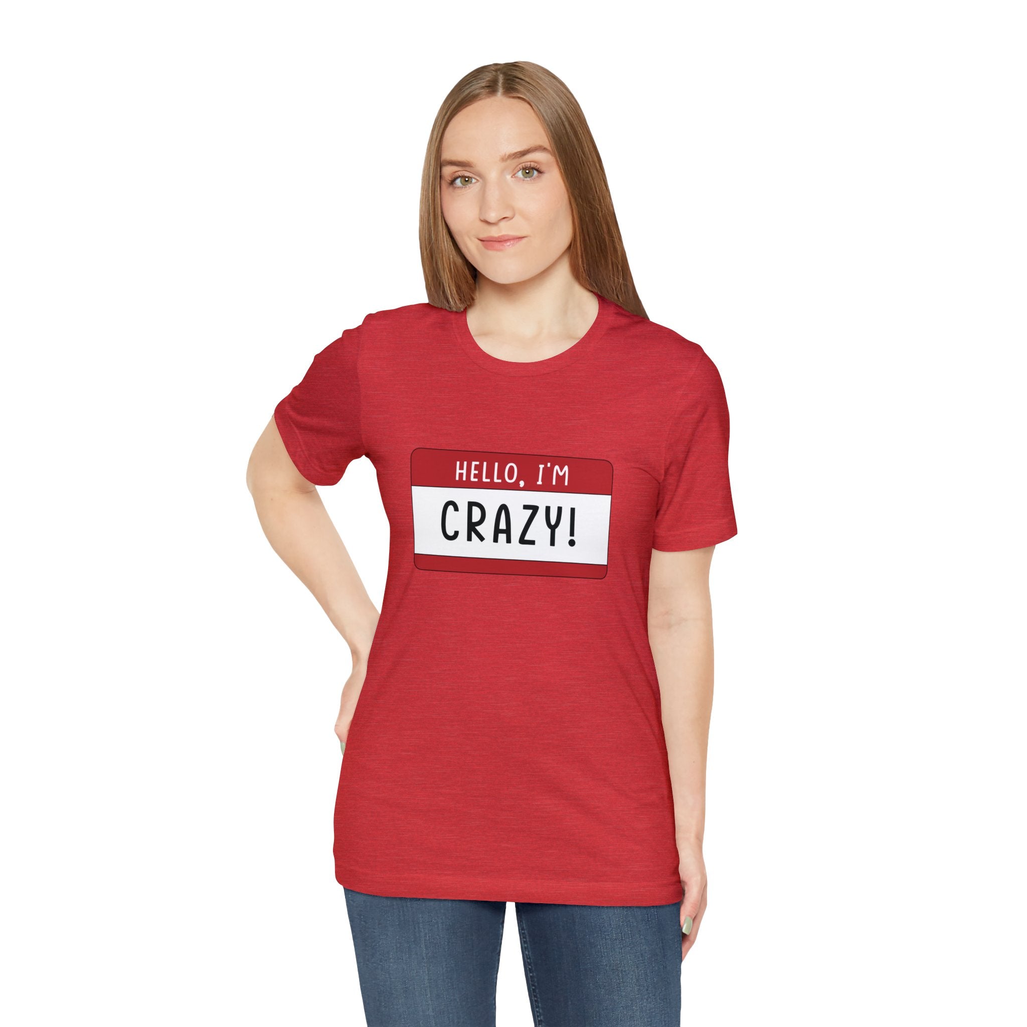 A woman in a red t-shirt with a "Hello, I'm CRAZY T-Shirt" quirky t-shirt stands confidently against a white background.
