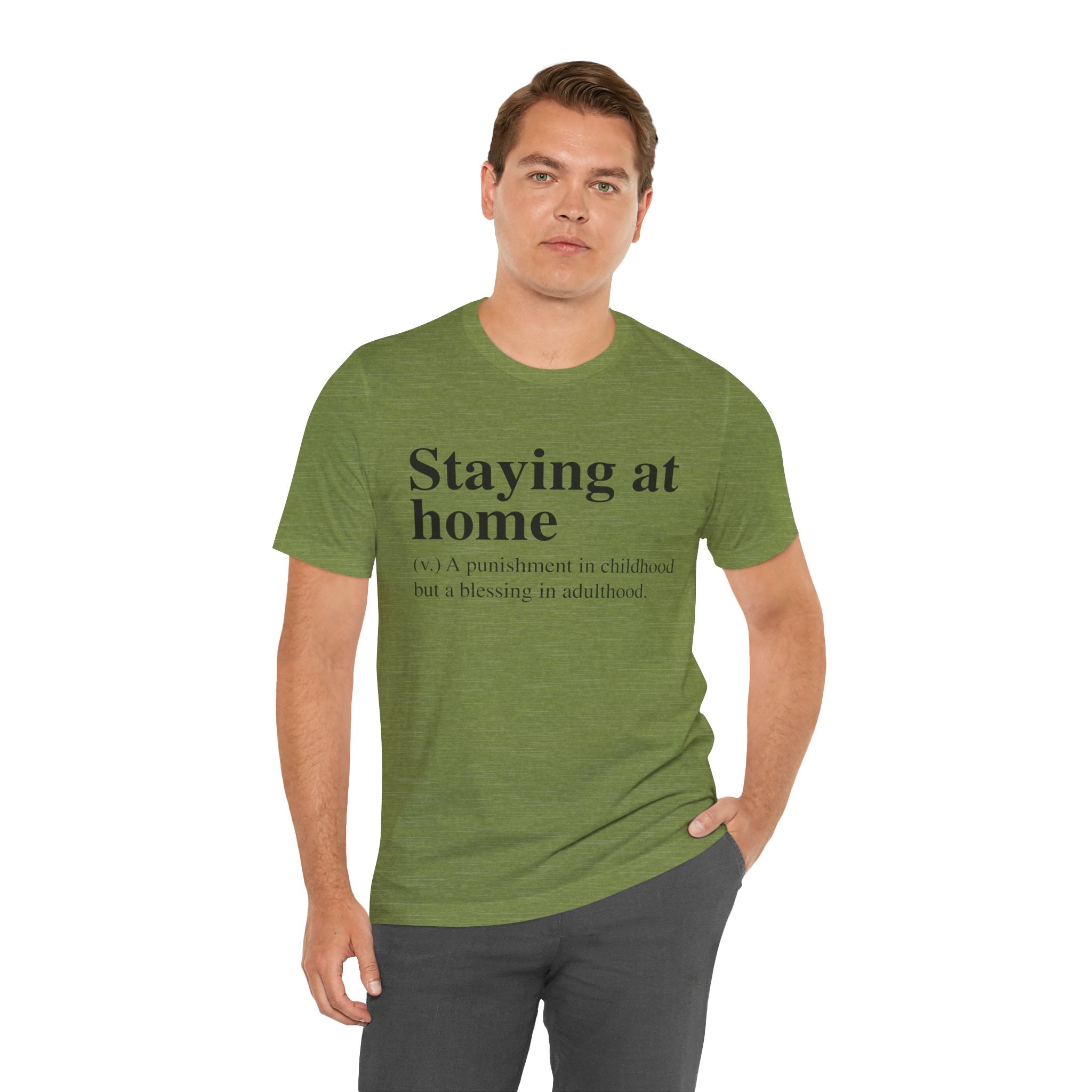 Man in green Staying at Home T-Shirt with text "staying at home - a punishment in childhood but a blessing in adulthood" standing against a plain background.