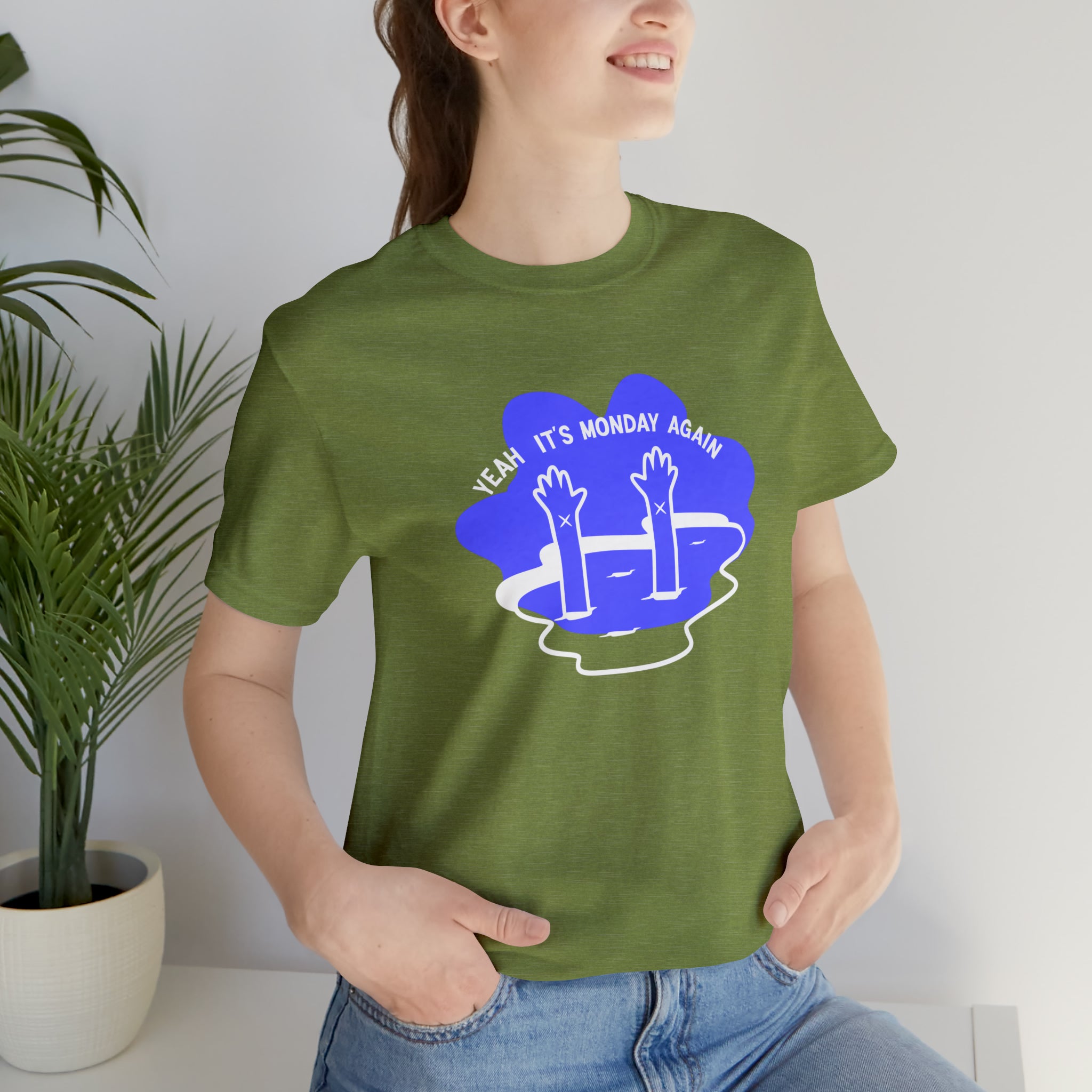 A woman wearing her favorite Yeah Its Monday Again T-Shirt, a green cotton tee with a blue flower on it.