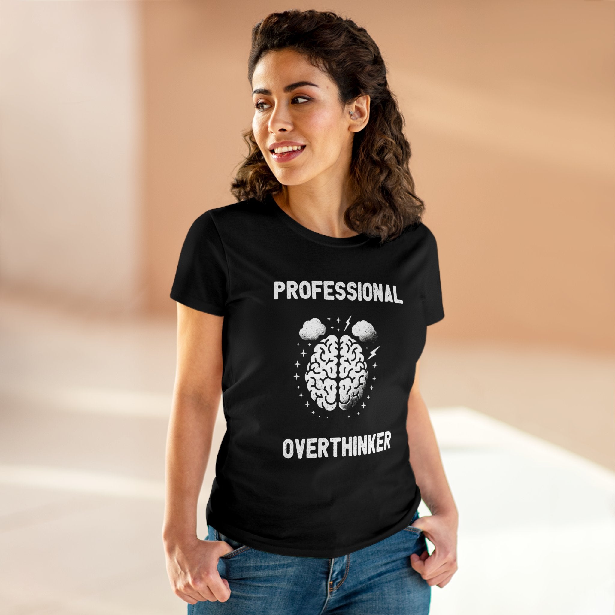 A person stands wearing a black, fitted silhouette T-shirt with the text "Professional Overthinker" and an illustrated brain design. The Professional Overthinker - Women's Tee is made from soft light cotton, ensuring comfort and style.