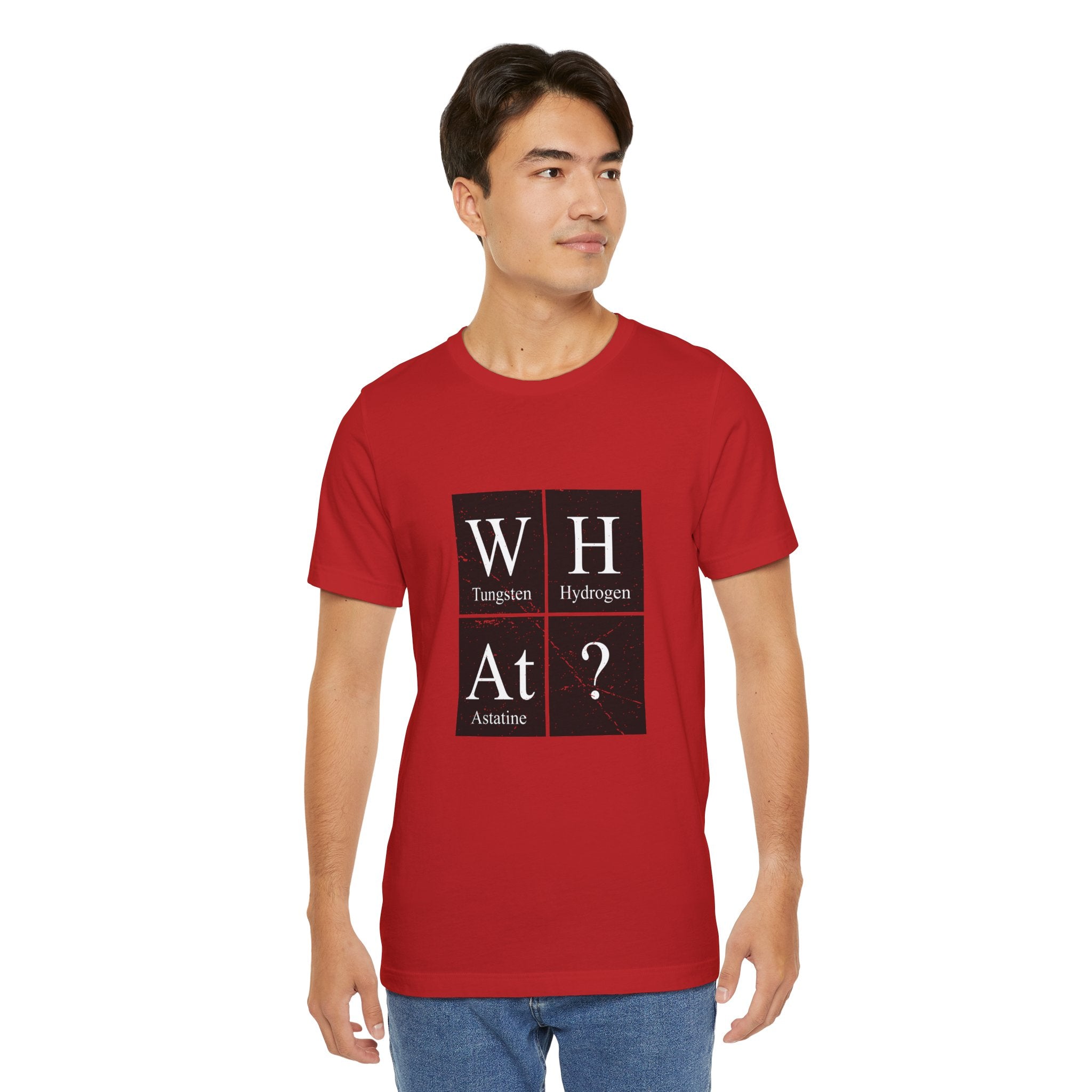 Young man wearing a red unisex jersey tee with the W-H-At-? design that spells "what?" with tungsten, hydrogen, and astatine symbols.