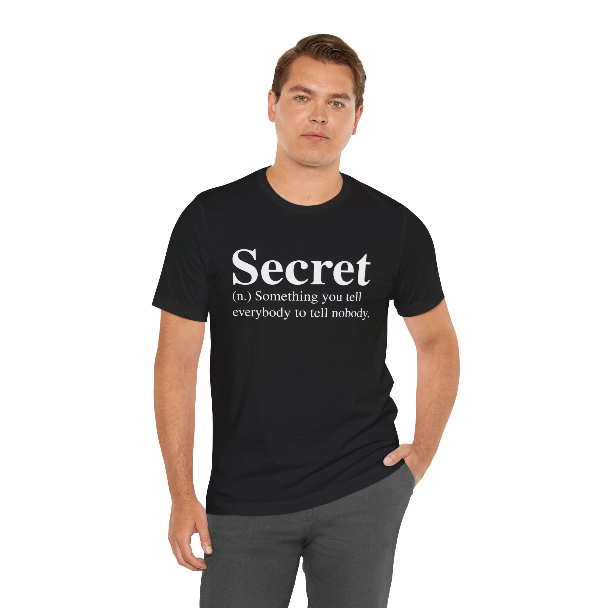A man in a black, soft cotton Secret T-Shirt with a definition of "secret" printed on it, standing against a white background.