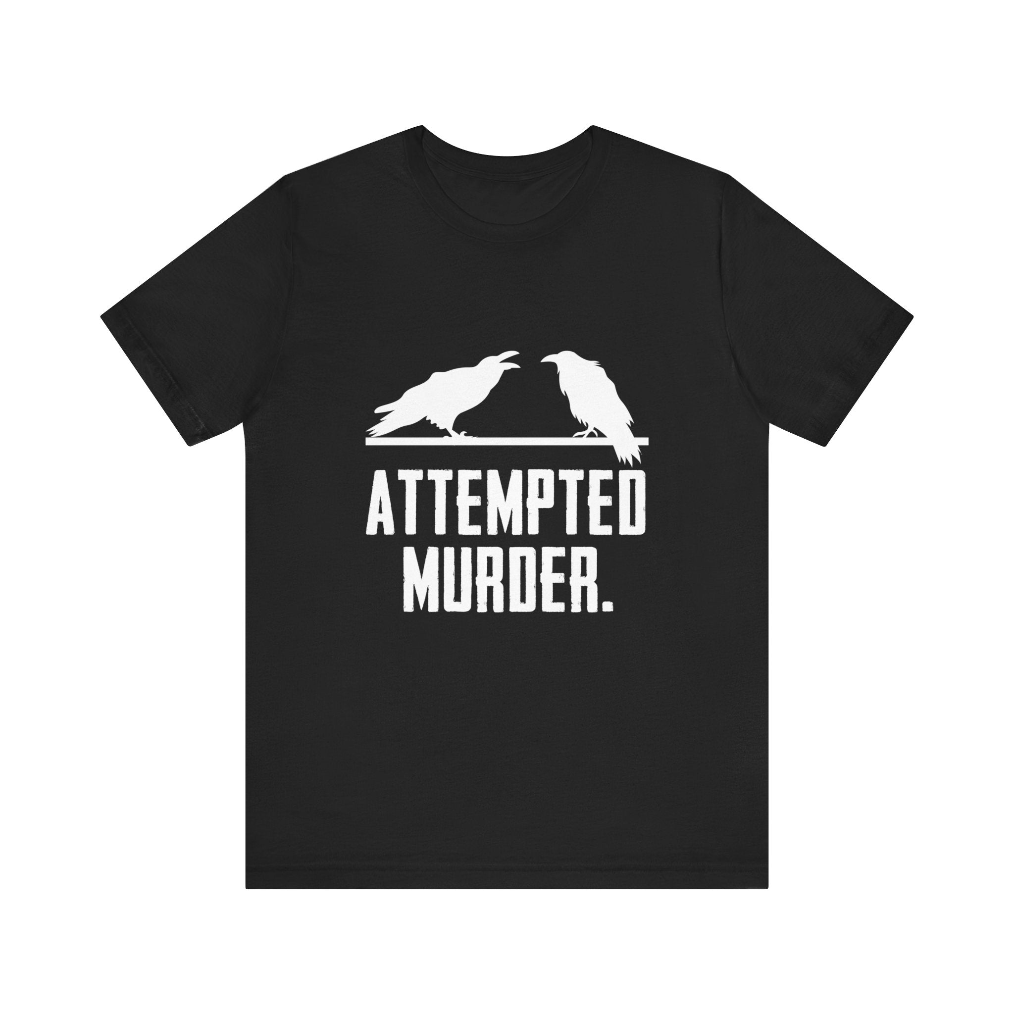 The Attempted Murder T-Shirt is a stylish piece with two white crows set against a sleek black background, accompanied by the playful text "Attempted Murder," making it perfect for displaying your unique sense of humor.