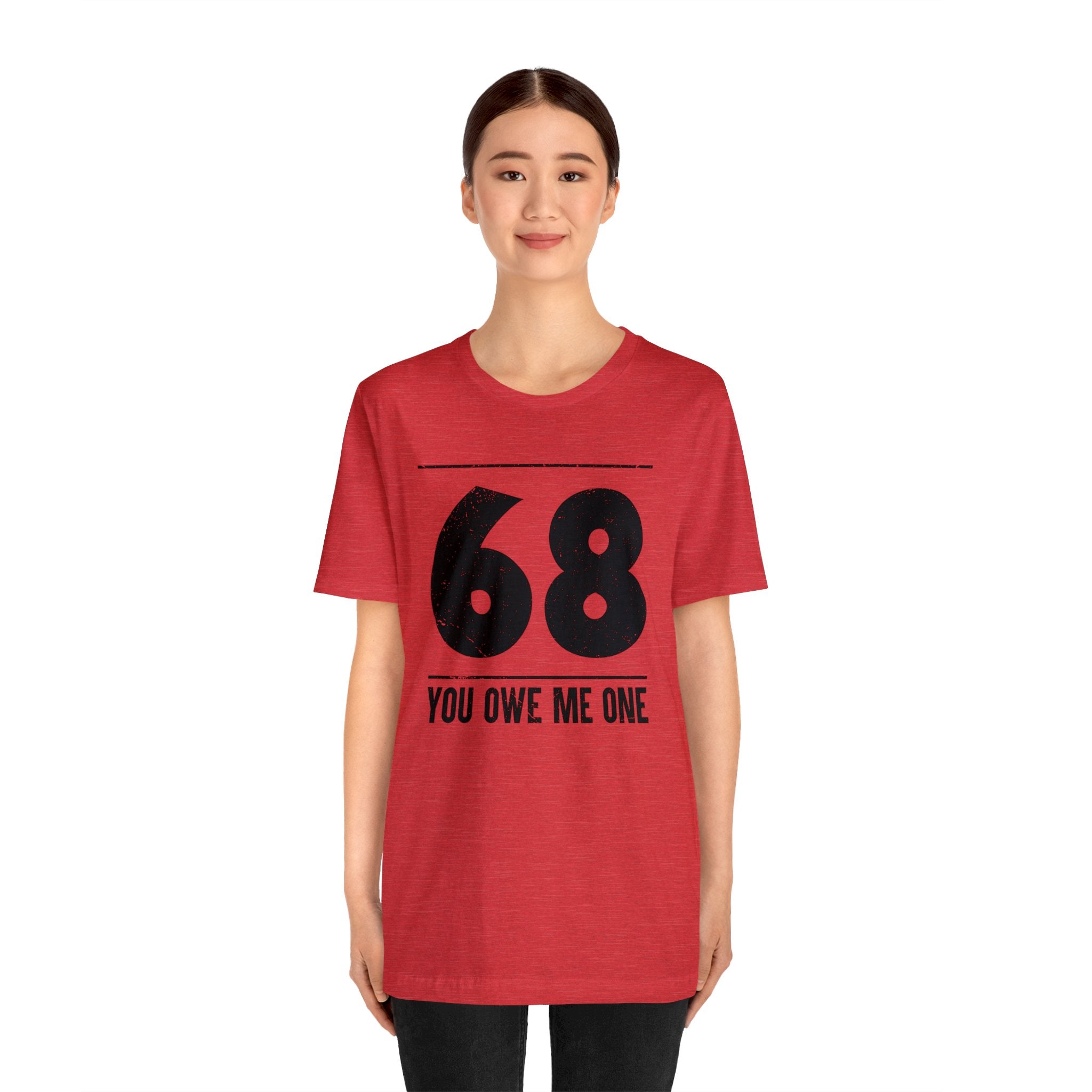 A woman in a geeky red t-shirt that says "68 You Owe Me One".