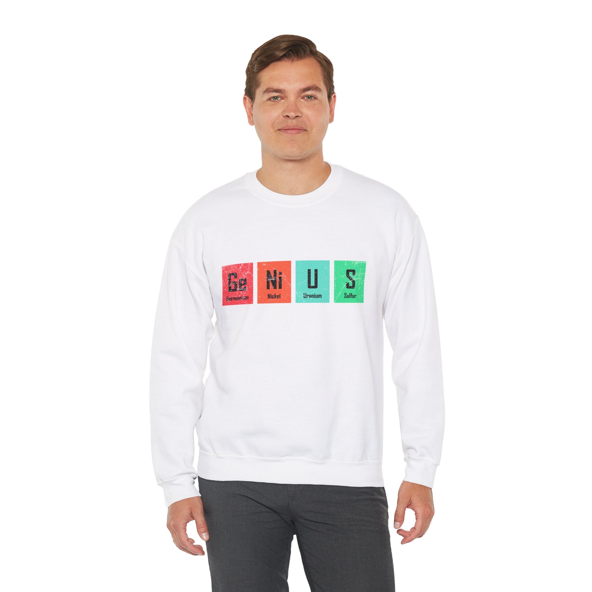 A man wearing a comfortable white Ge-Ni-U-S - Sweatshirt with blocks featuring elements from the periodic table spelling "Genius" stands against a plain white background, exuding an air of both intellect and warmth.