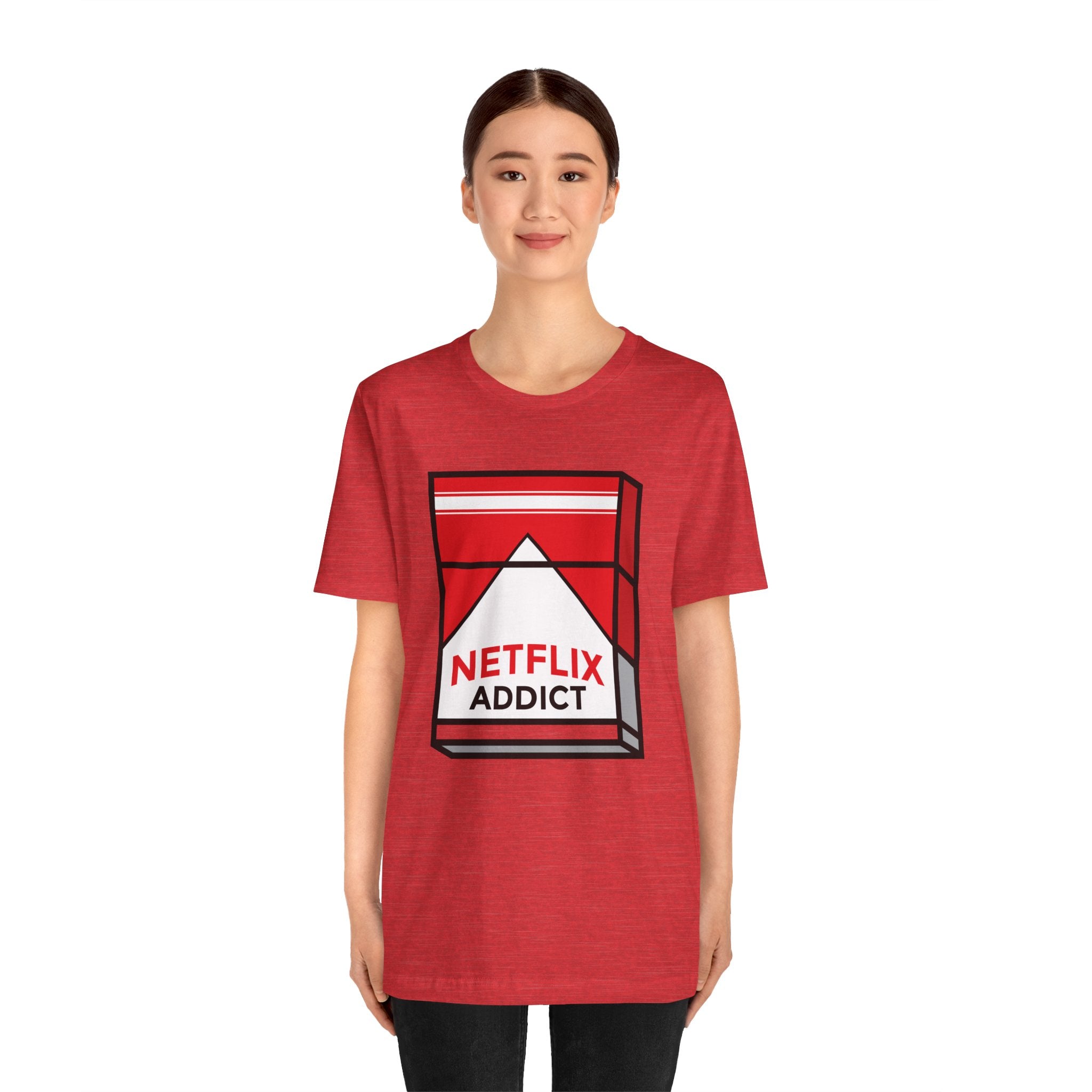 Young woman in a red unisex jersey tee featuring a "Netflix Addict" graphic with a play button symbol.