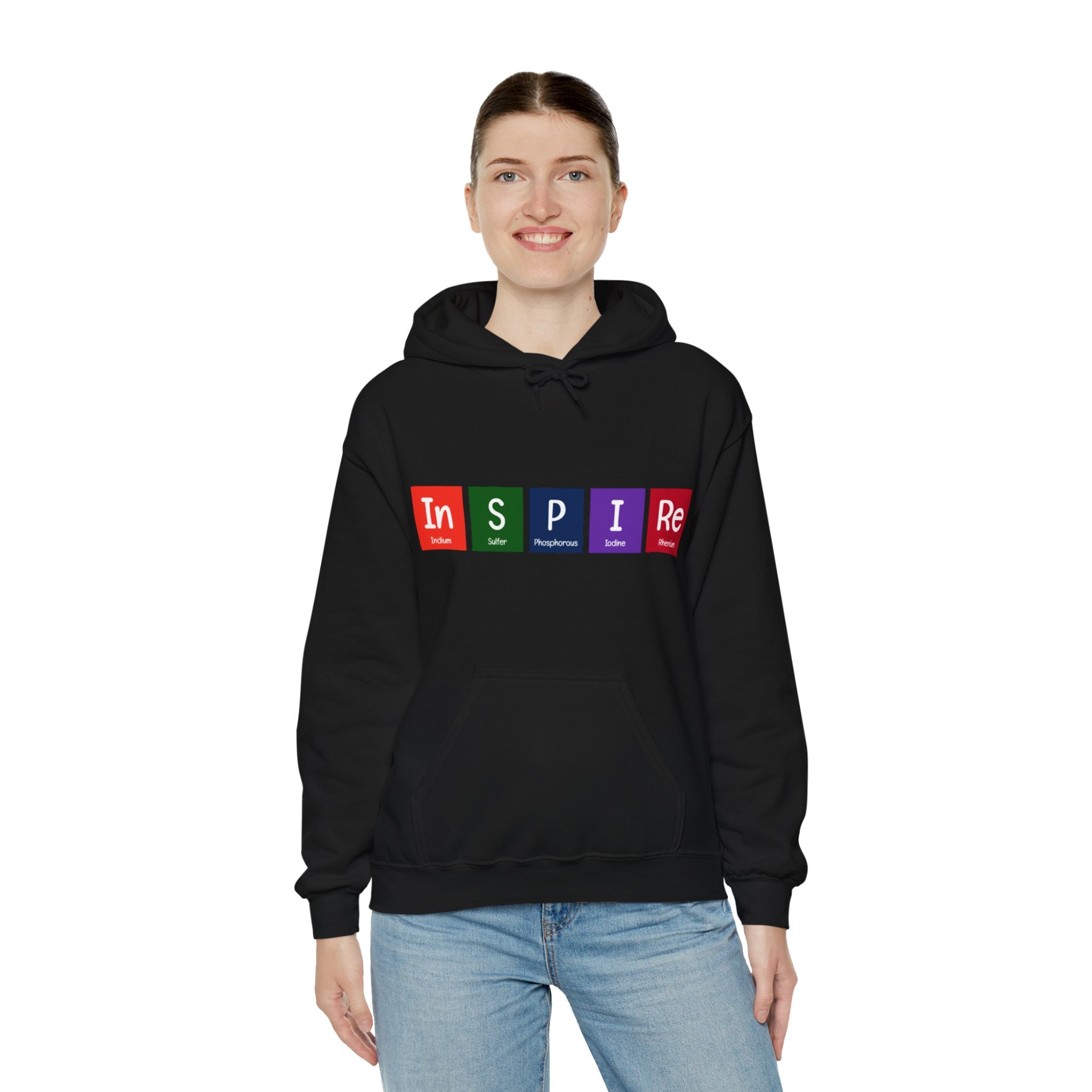 A person wearing the In-S-P-I-Re - Hooded Sweatshirt, a black hoodie with the word "INSPIRE" spelled out in colorful periodic table-like blocks. Perfect for daily wear, this comfy sweatshirt combines style and inspiration effortlessly.