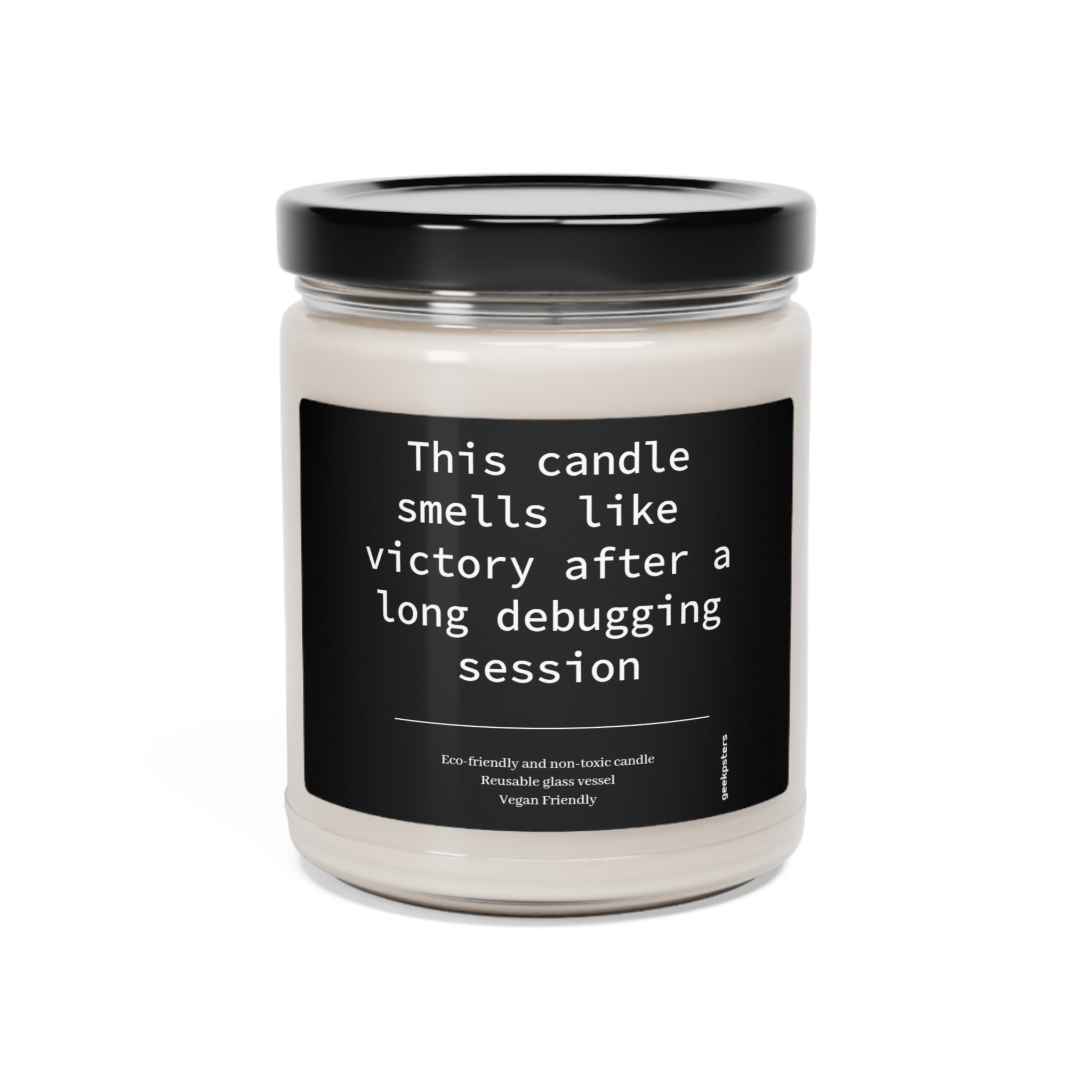 A "This Candle Smells Like Victory After a Long Debugging Session" soy candle in a clear jar with a label that reads it's eco-friendly and vegan.