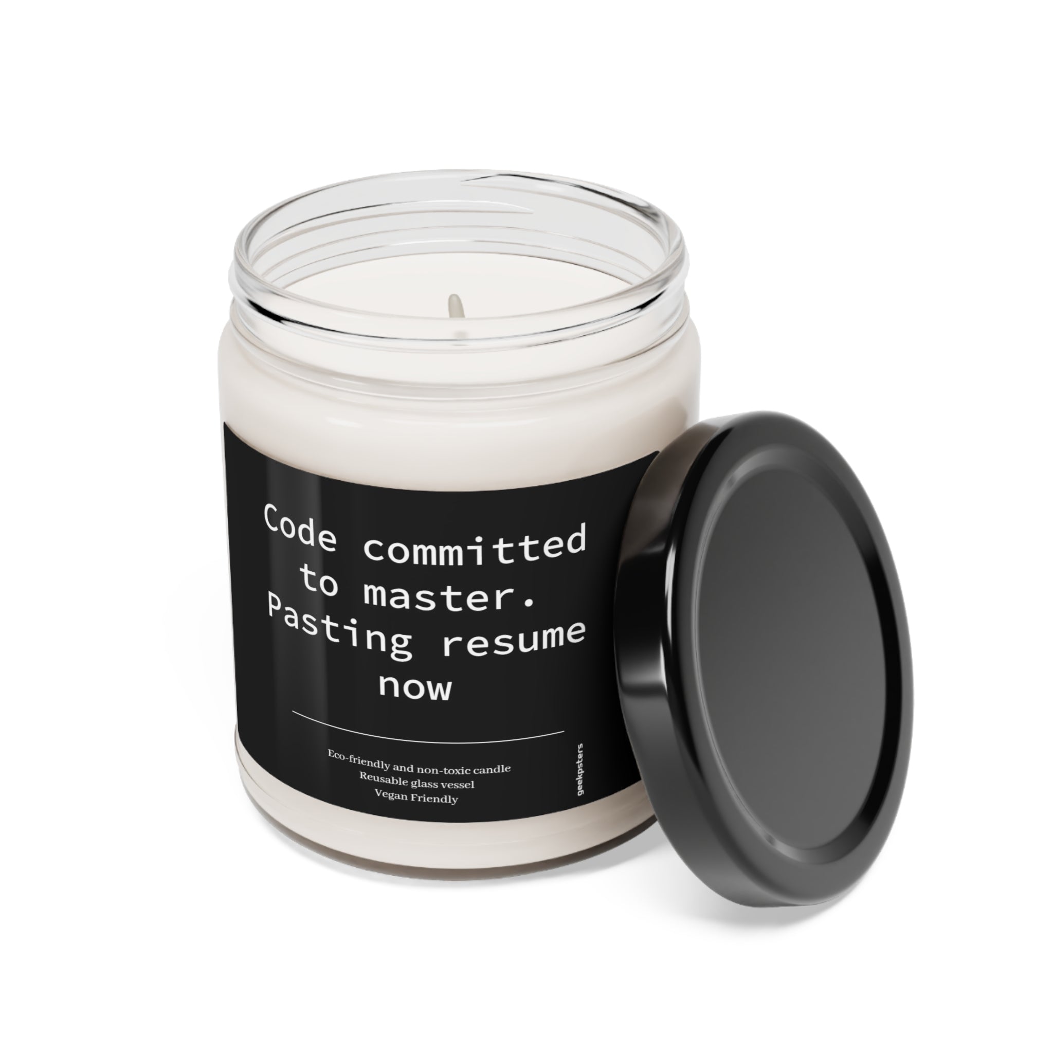 A Code Committed to Master. Pasting Resume Now scented soy candle in a glass jar with a humorous label that reads "code committed to master. pasting resume now" suggesting a developer joking about the consequences of pushing code directly to the master branch