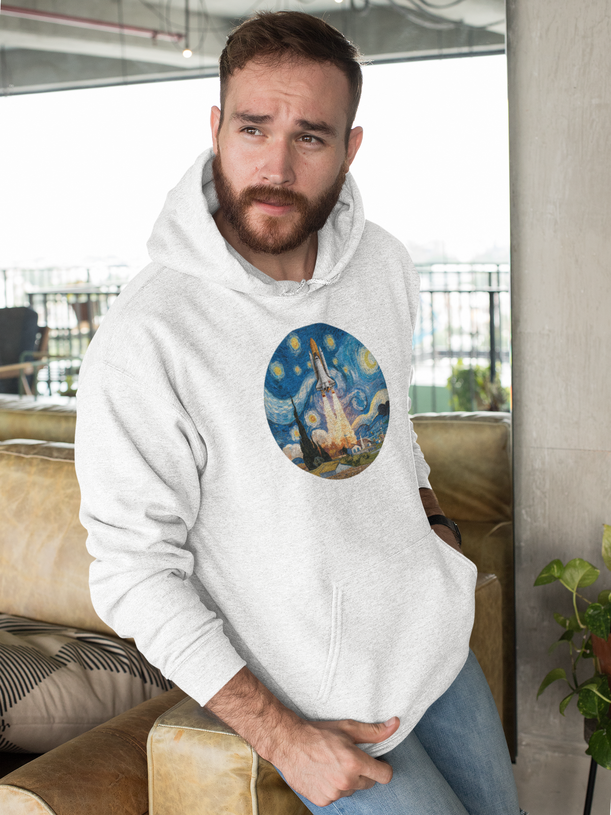 Van Gogh Spaceship Hoodie in white, bearded man wearing it relaxing indoors, cozy starry night pullover