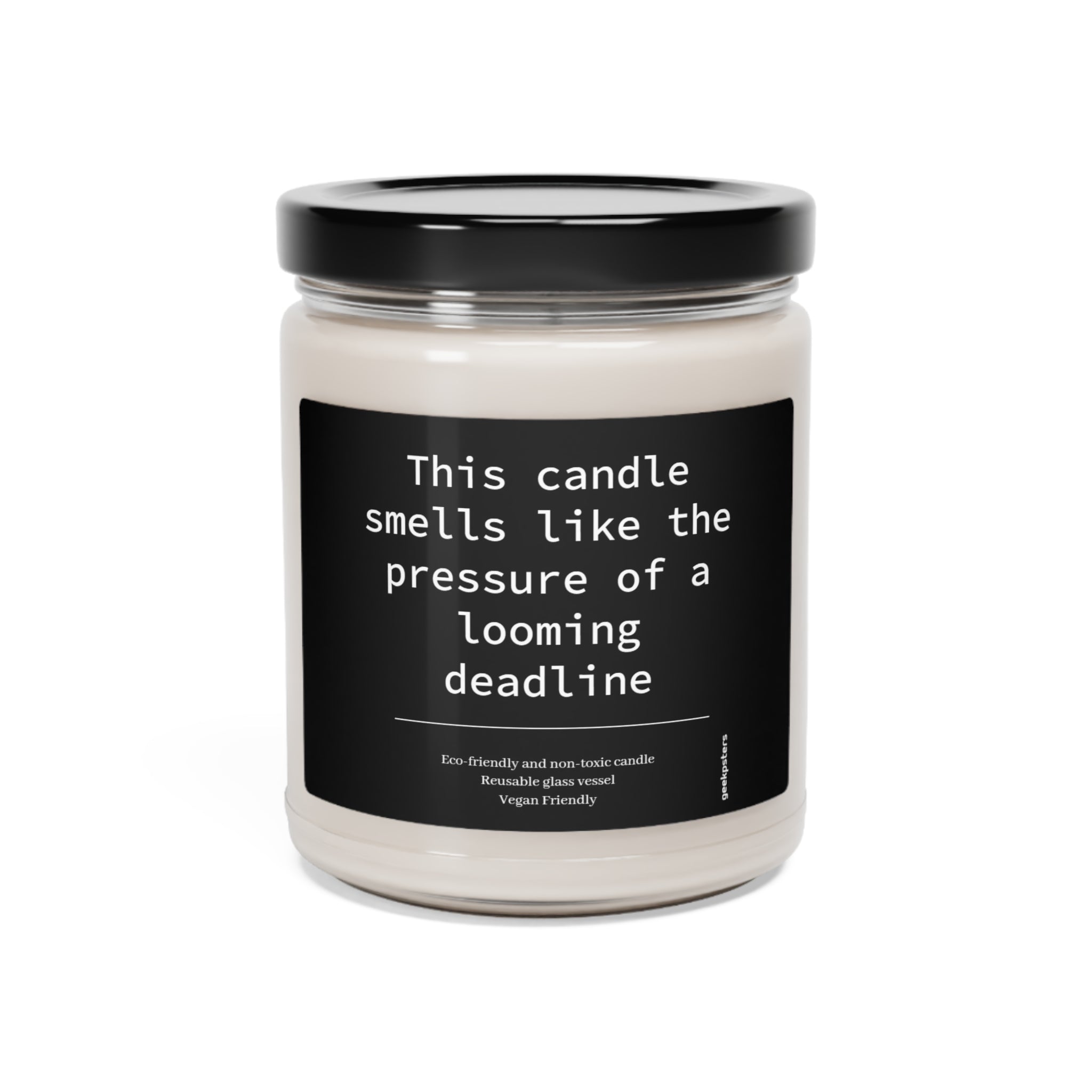 A "This Candle Smells Like the Pressure of a Looming Deadline" 9oz soy candle in a glass jar with the label, indicating it's eco-friendly and vegan-friendly.