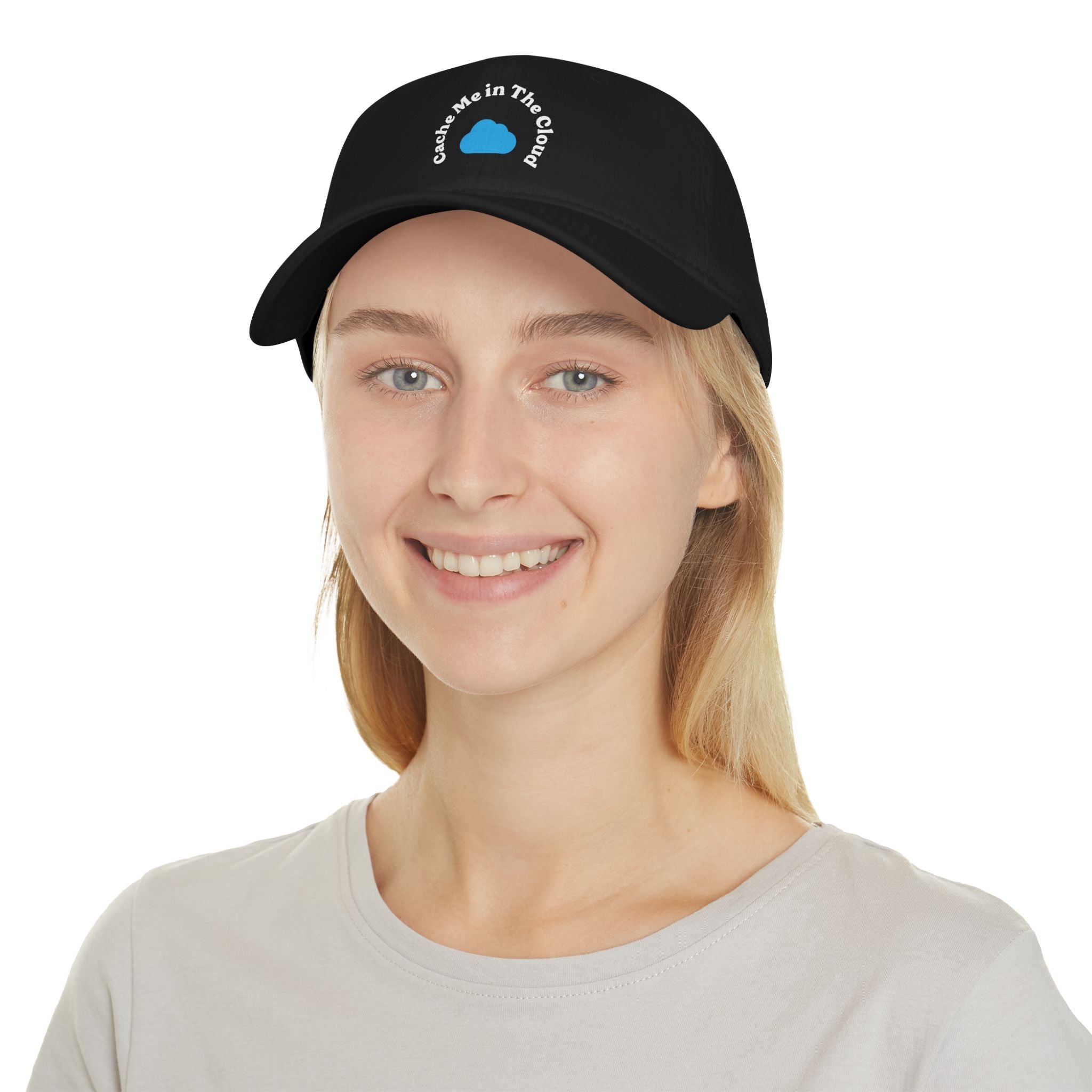 A person sporting the "Cache Me in The Cloud" hat, featuring the blue circle logo, smiles while wearing a light-colored shirt.