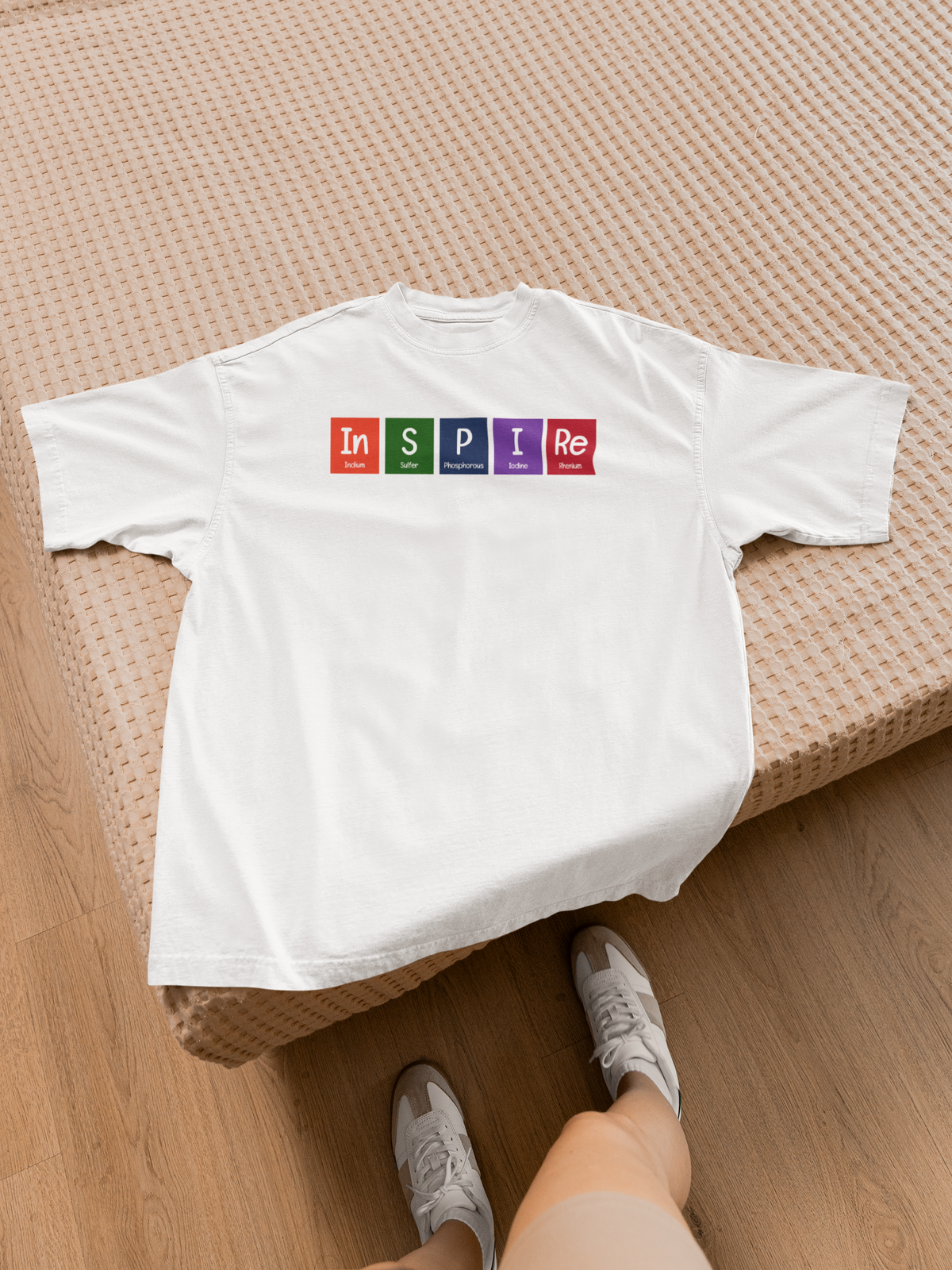 'InSPIRe' periodic table t-shirt in white, laid flat on a wooden bench outdoors, fun gift idea