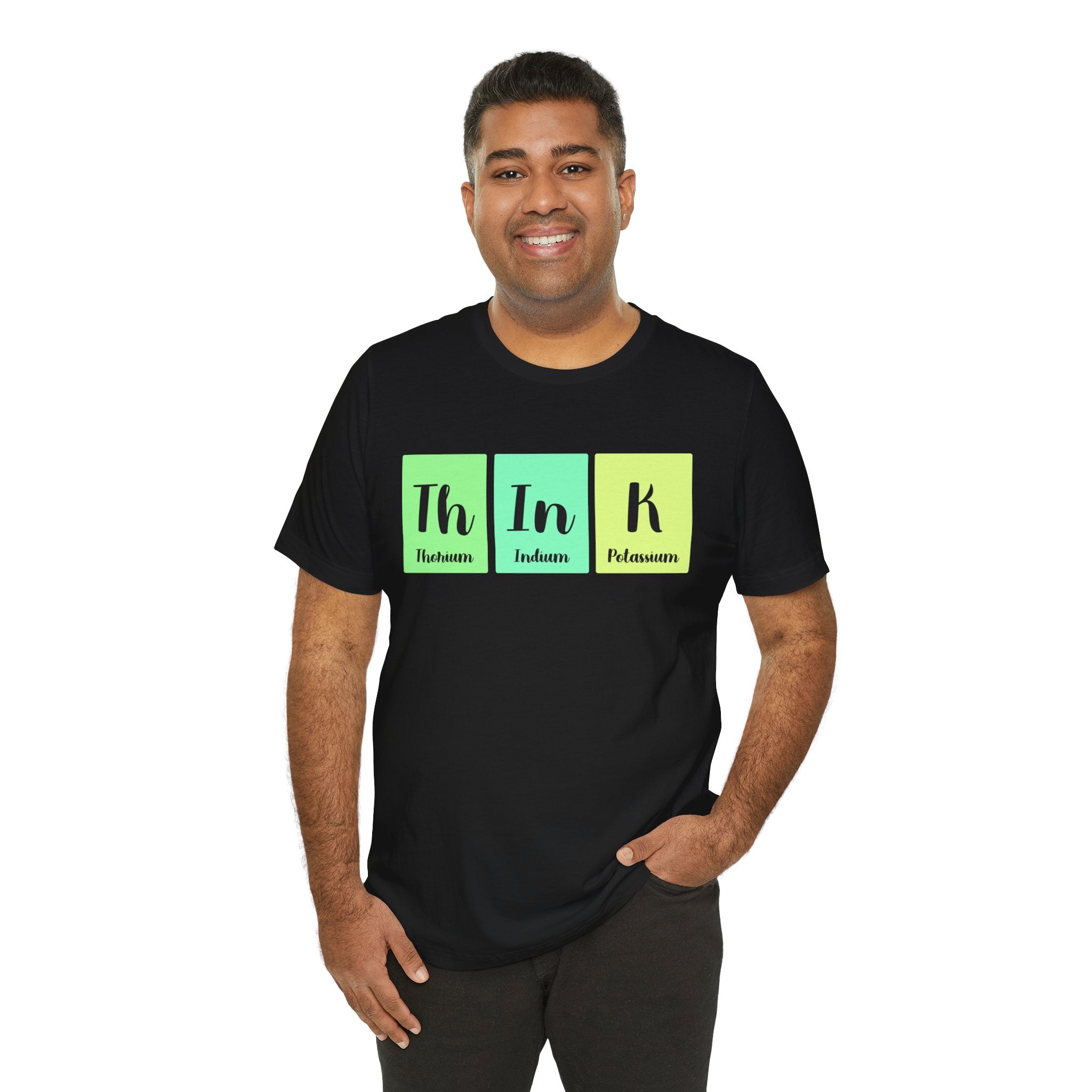 Man smiling, wearing a Th-In-k unisex jersey tee in black with "th in k" in green, blue, and yellow, representing elements thorium, indium, and potassium.