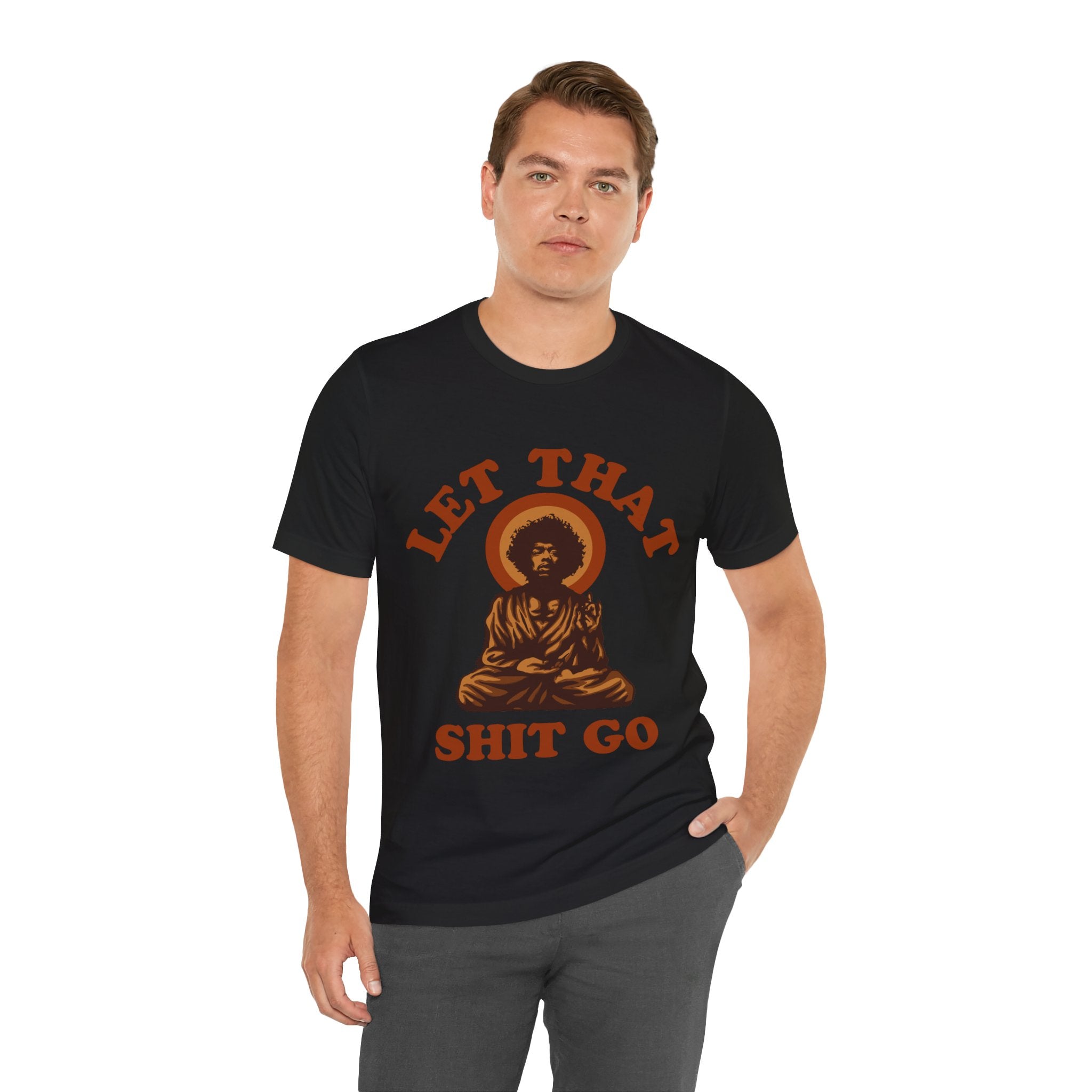 Man in a black Let That Shit Go T-shirt with a humorous design featuring a meditating figure and the phrase displayed on it.