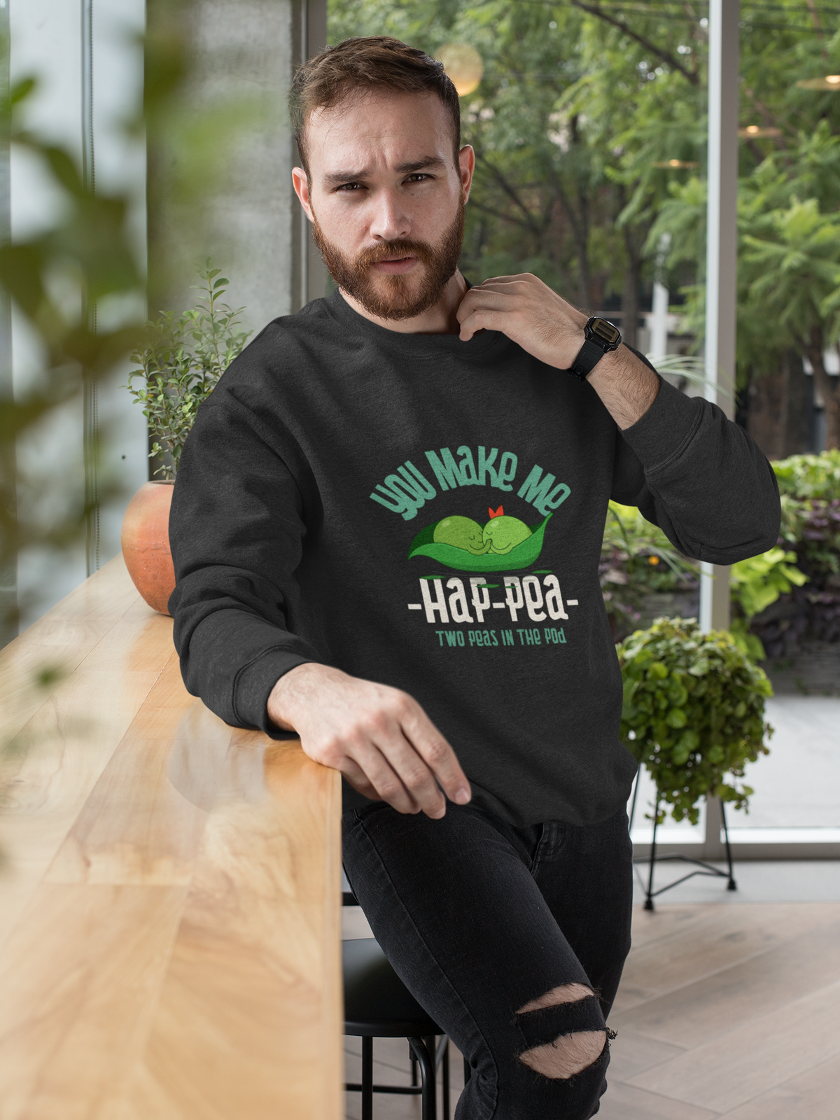 'You Make Me Ha-Pea' pea pun sweatshirt in black, bearded man wearing it outdoors, veggie pun gift