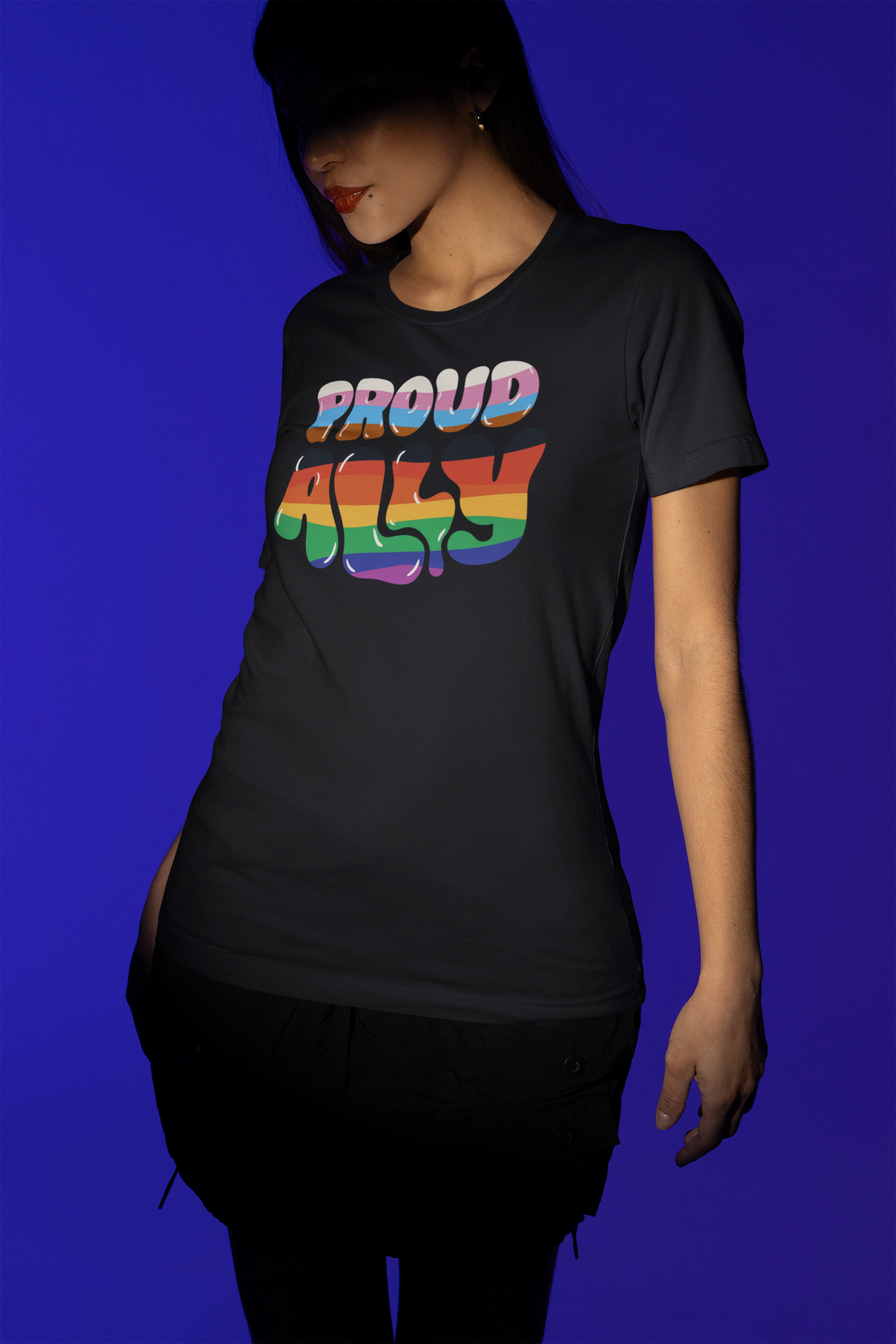 'Proud Ally' T-shirt in black, woman wearing it against a blue backdrop, gift for pride allies