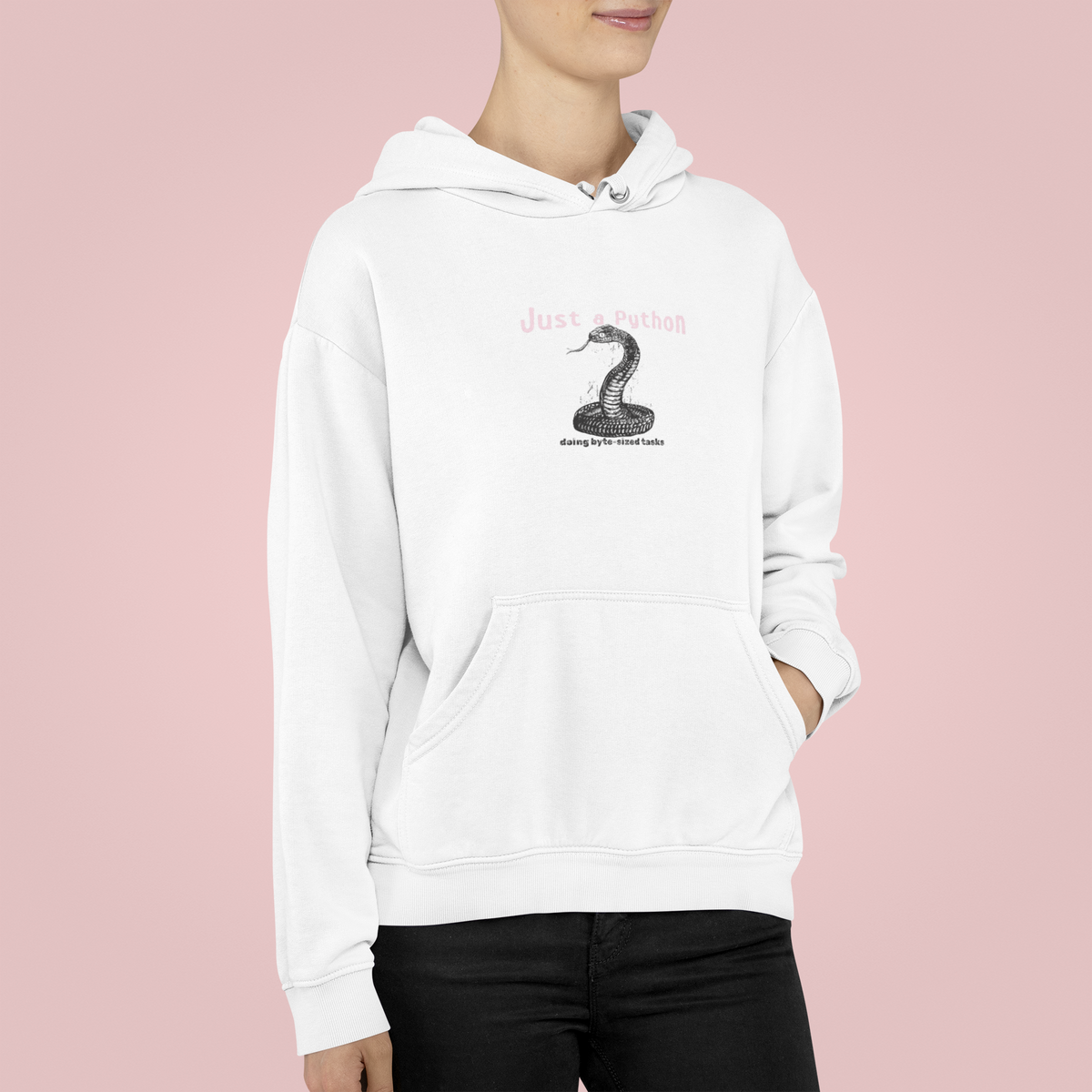 'Just a Python' snake graphic hoodie in white, woman wearing it, pink backdrop, funny coder gift