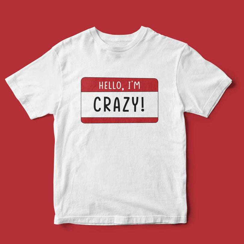 Hello, I'm CRAZY T-Shirt with a unique design featuring a red and white name tag that reads "hello, i'm crazy!" displayed on a plain red background.
