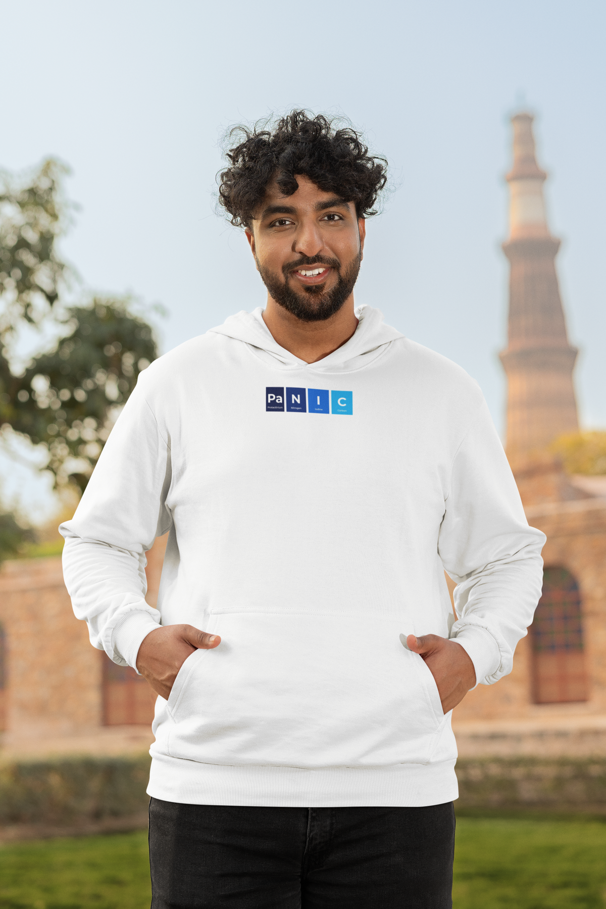 'Pa-N-I-C Periodic Table Hoodie' in white, man by a historic building, Hoodie mockup, Geekpsters