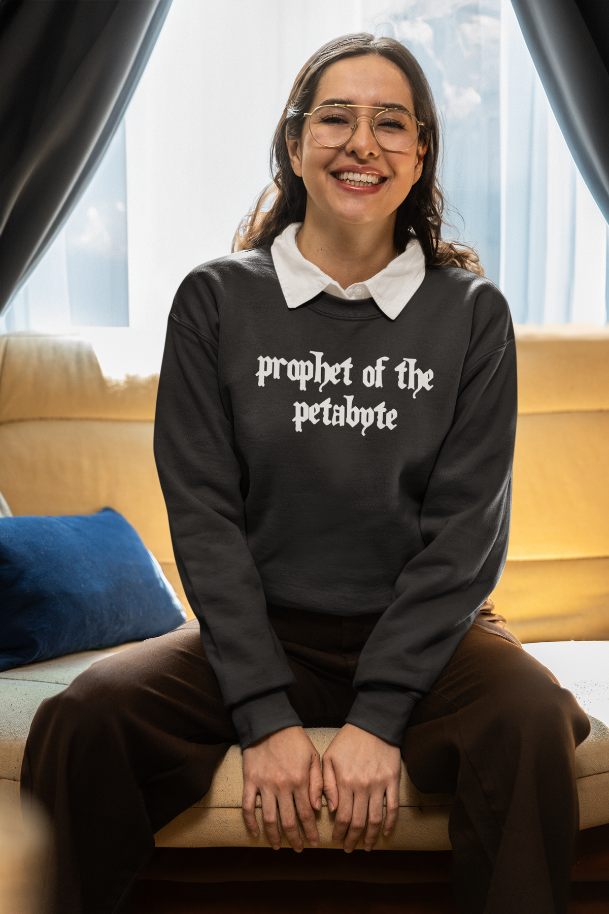 'Prophet of the Petabyte' sweatshirt in charcoal, woman sitting on a couch, funny tech sweatshirt gift