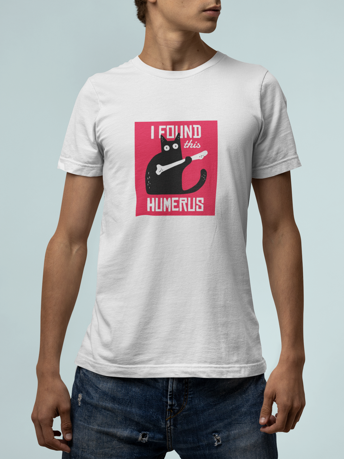 'I Found This Humerus' t-shirt in white, man against a light backdrop