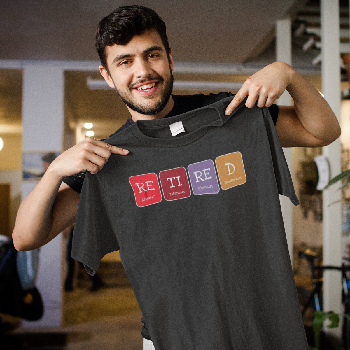 'Retired' periodic table t-shirt in heather charcoal, smiling man holding it up, funny retirement gift