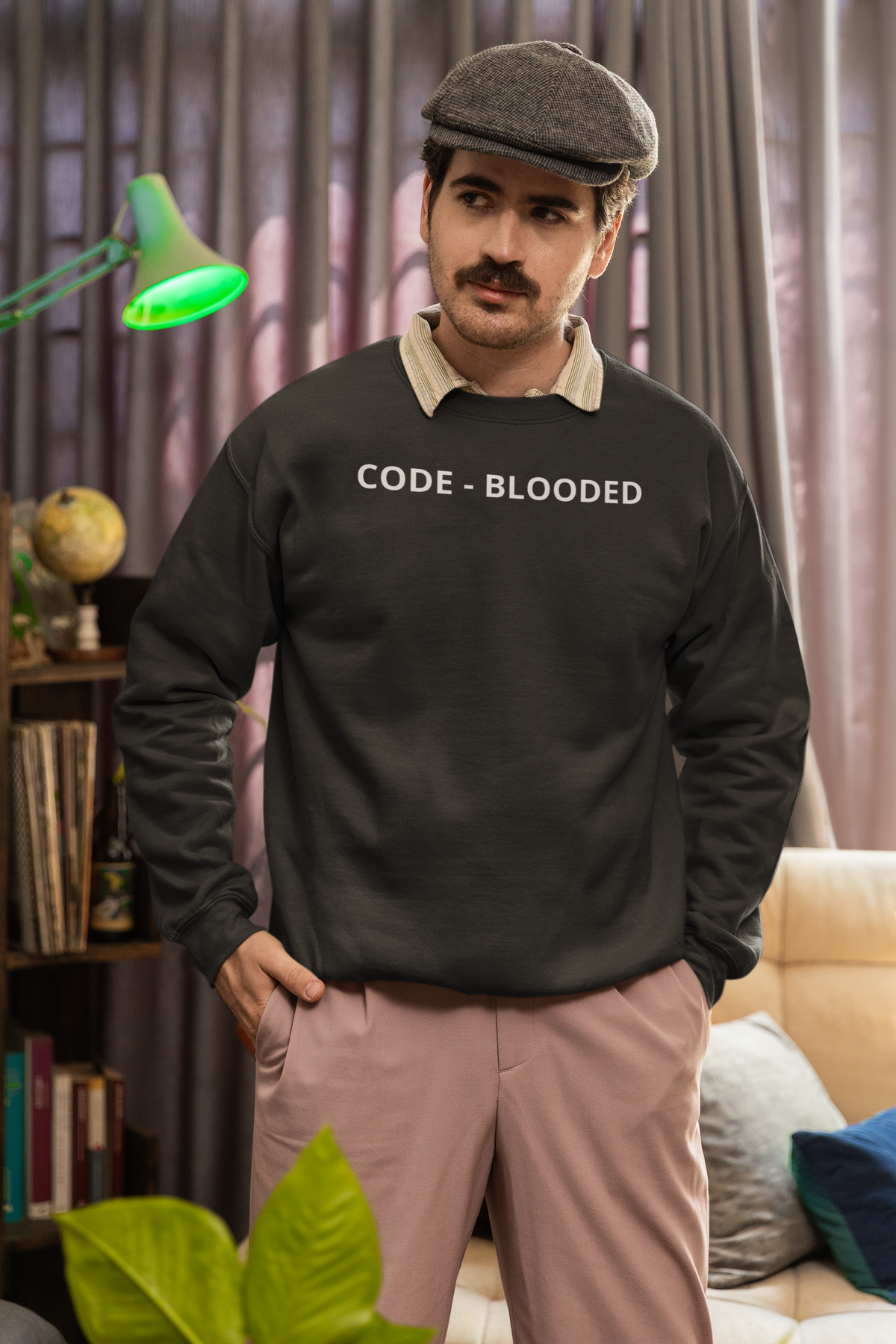 'Code - Blooded' sweatshirt in charcoal, man wearing it indoors with cap, funny gift for programmers
