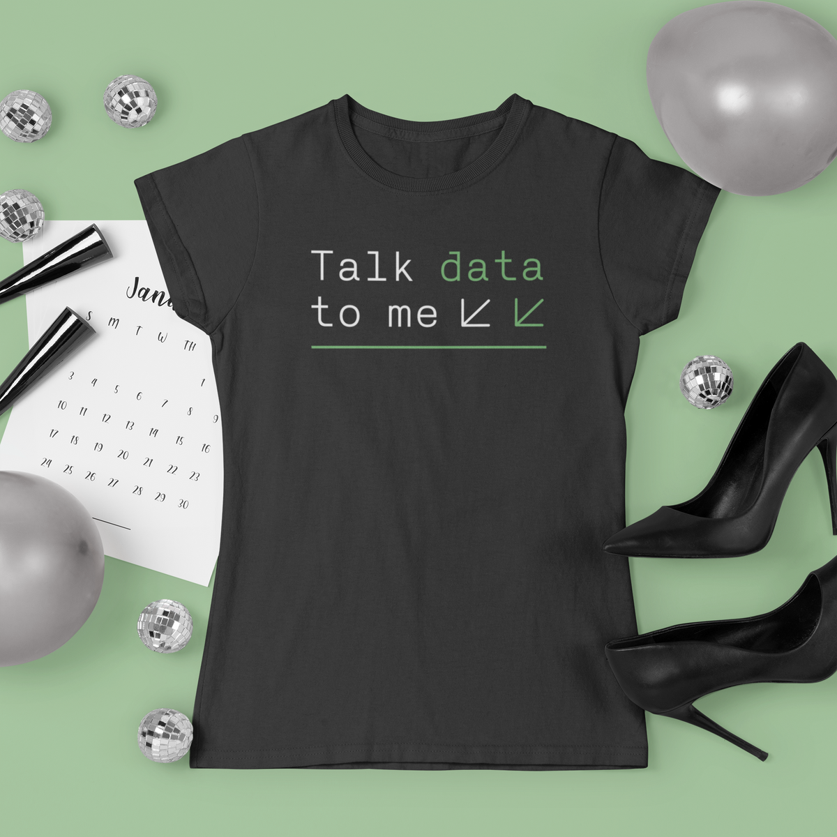 'Talk Data to Me' t-shirt in black, flat lay styled with stationery and heels on green