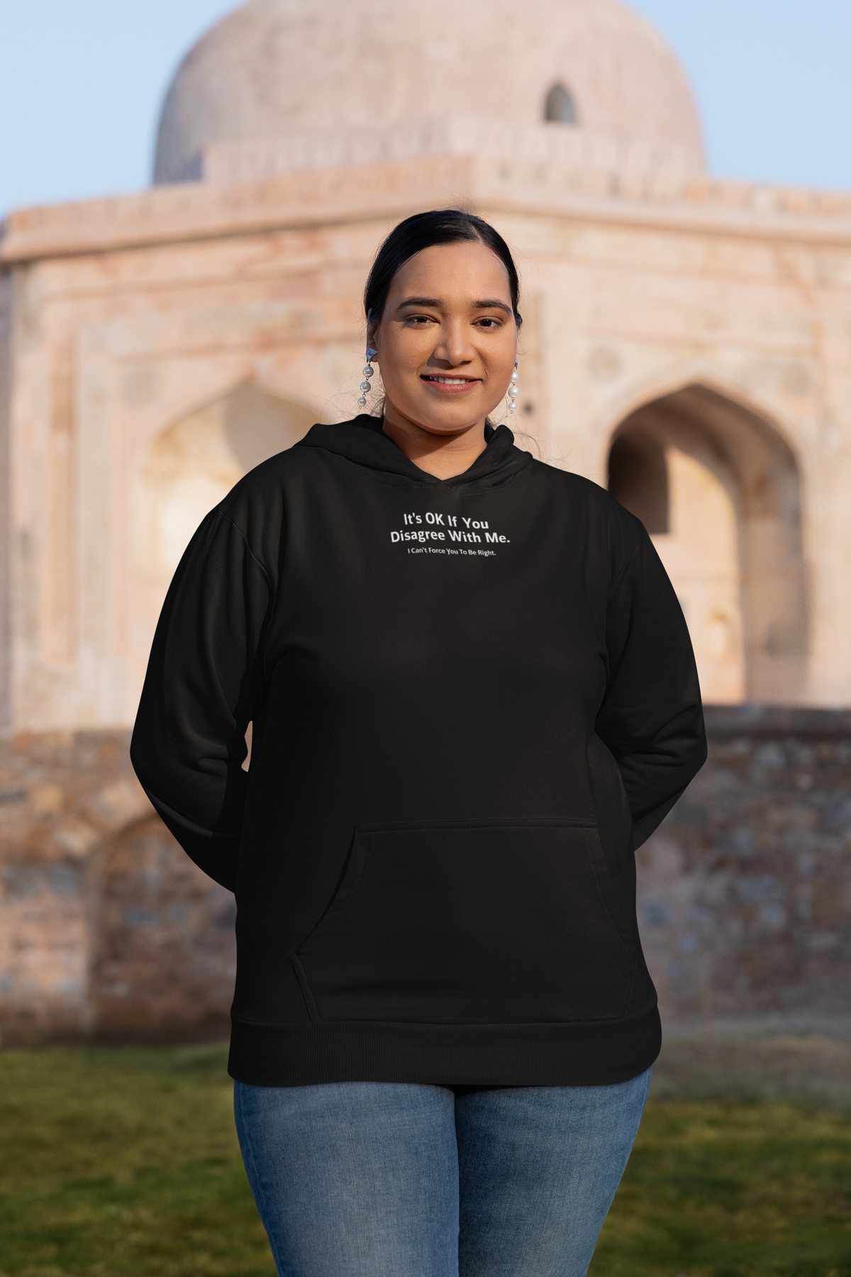 'It's Ok If You Disagree Hoodie' in black, woman at a historic monument, Hoodie mockup, Geekpsters