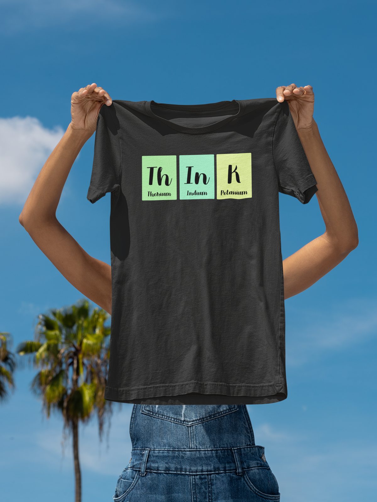 'ThInK' periodic table t-shirt in black, man holding it up outdoors, science teacher gift