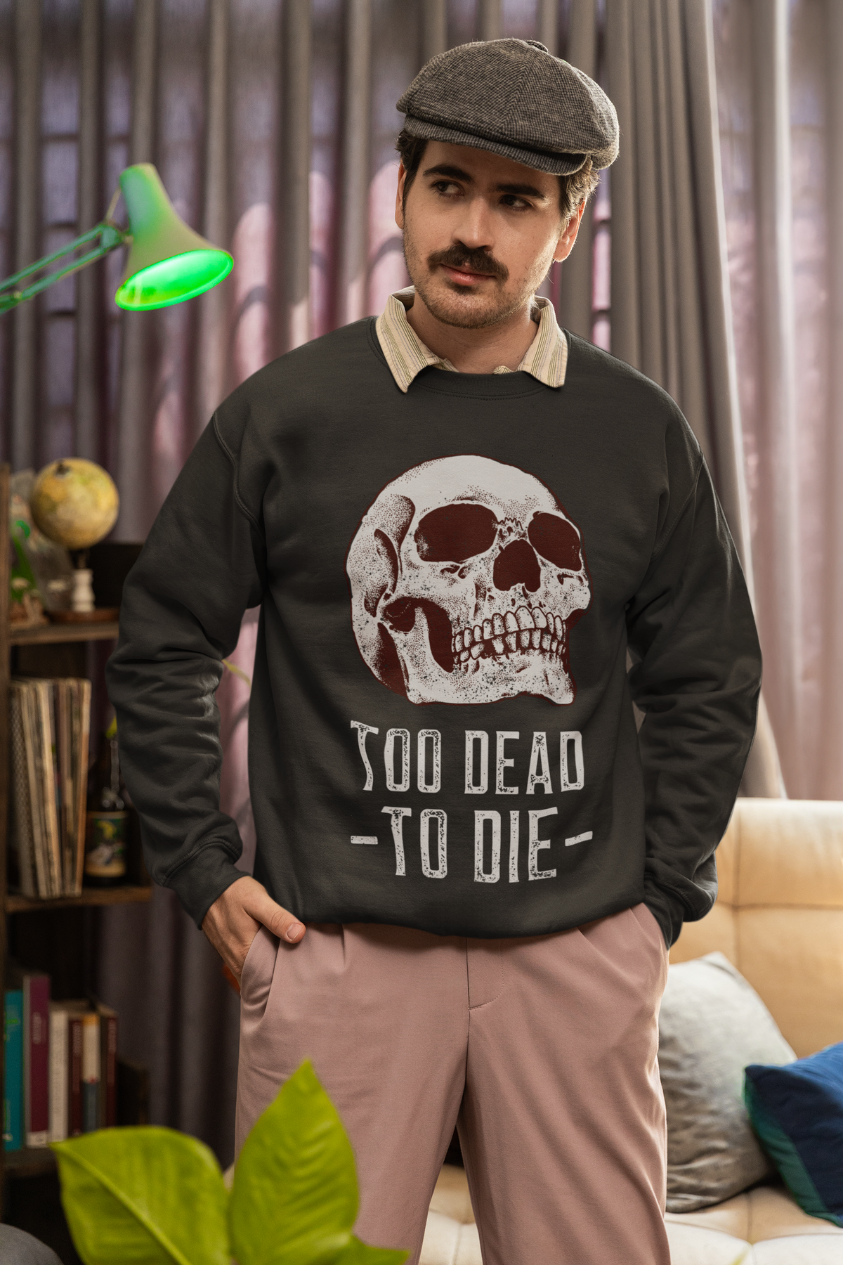 'Too Dead To Die' skull graphic sweatshirt in black, man wearing it indoors with a cap, gothic gift