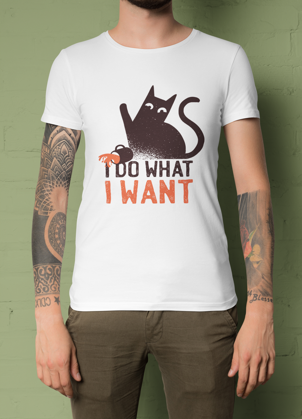 'I Do What I Want' cat t-shirt in white, tattooed man model wearing it against a green background, funny cat gift