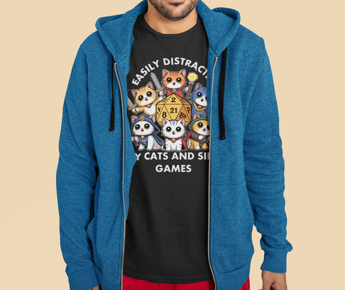 'Easily Distracted by Cats and Side Games' t-shirt in black, man wearing it under teal hoodie outdoors, gamer gift