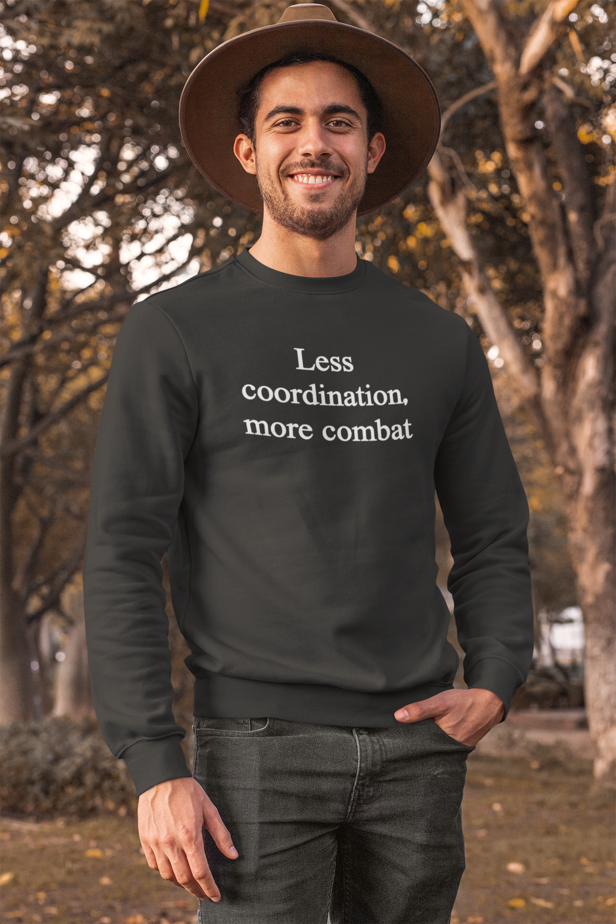 'Less Coordination More Combat' sweatshirt in black, man modeling it with a hat, funny office gift