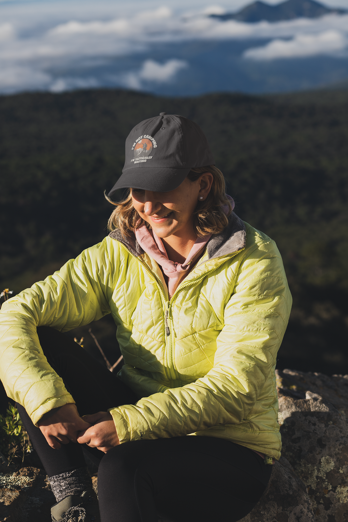 I'm Not Camping embroidered dad hat worn by a woman on a mountain hike, lifestyle mockup, Geekpsters