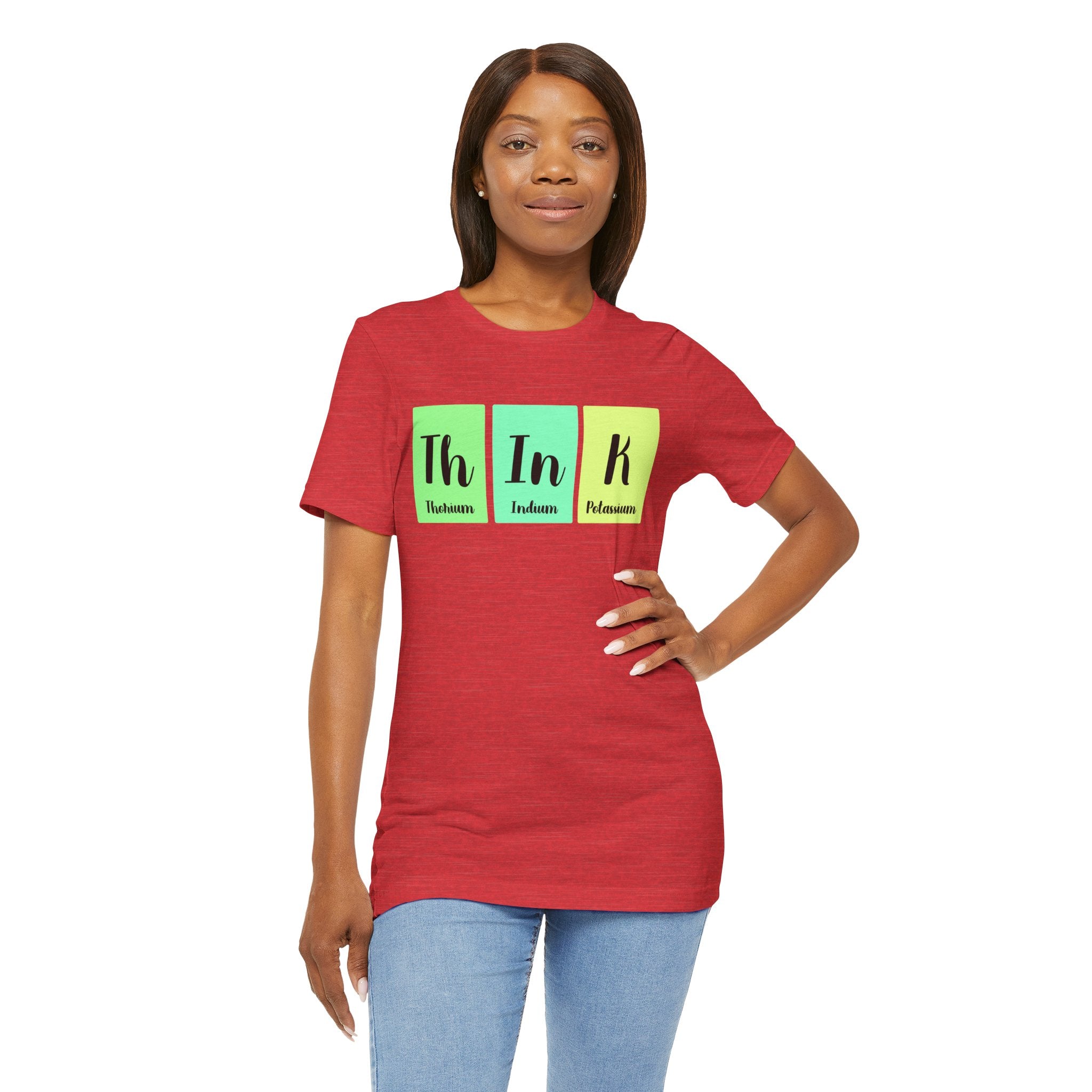 A woman in a Th-In-k red t-shirt with "th in k" printed in green, yellow, and blue blocks stands against a plain background.