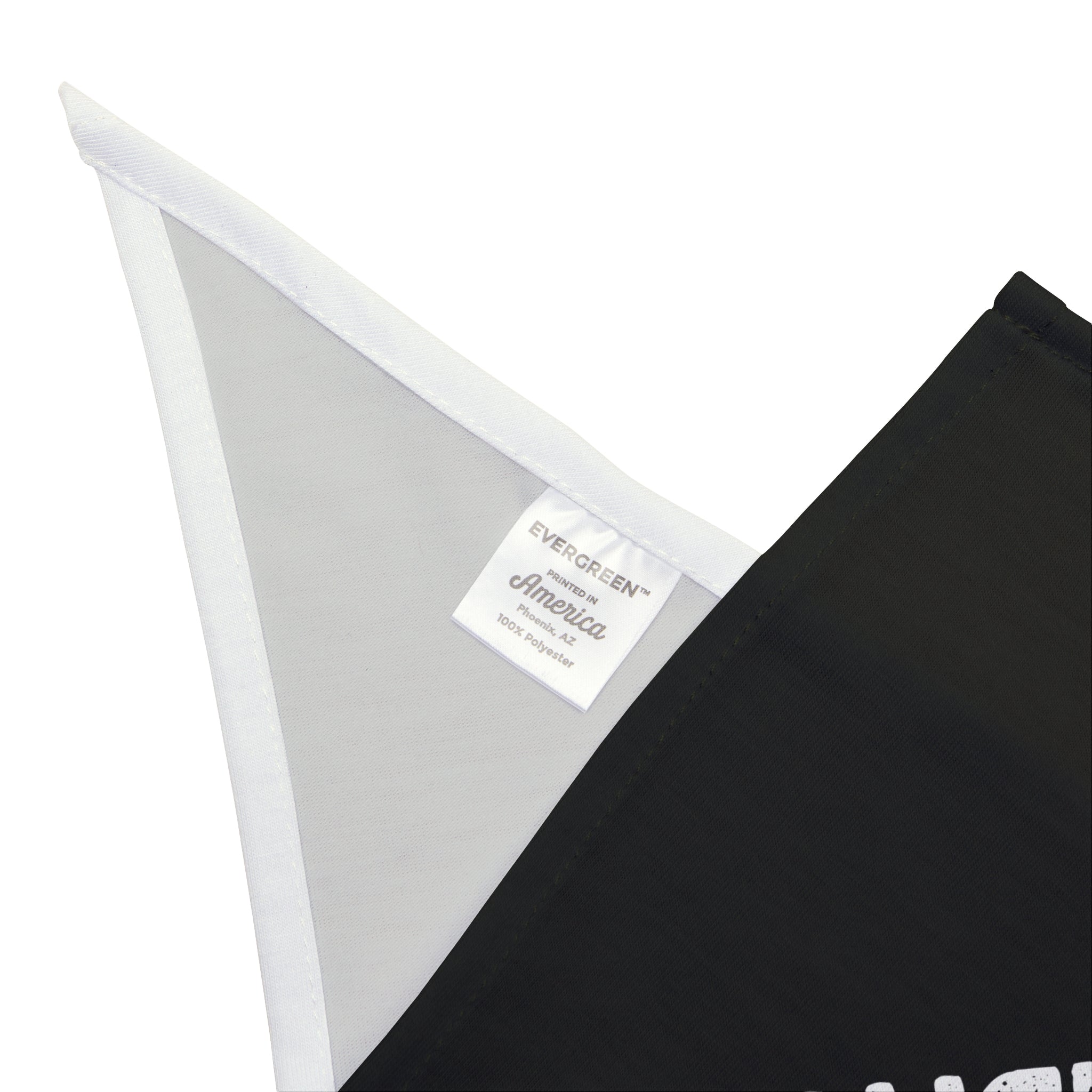 Close-up of a black and white fabric piece resembling the "Scaling Up My Ambition - Pet Bandana," with a label reading "Evergreen America 100% Polyester" sewn at the seam, highlighting its non-irritating material.