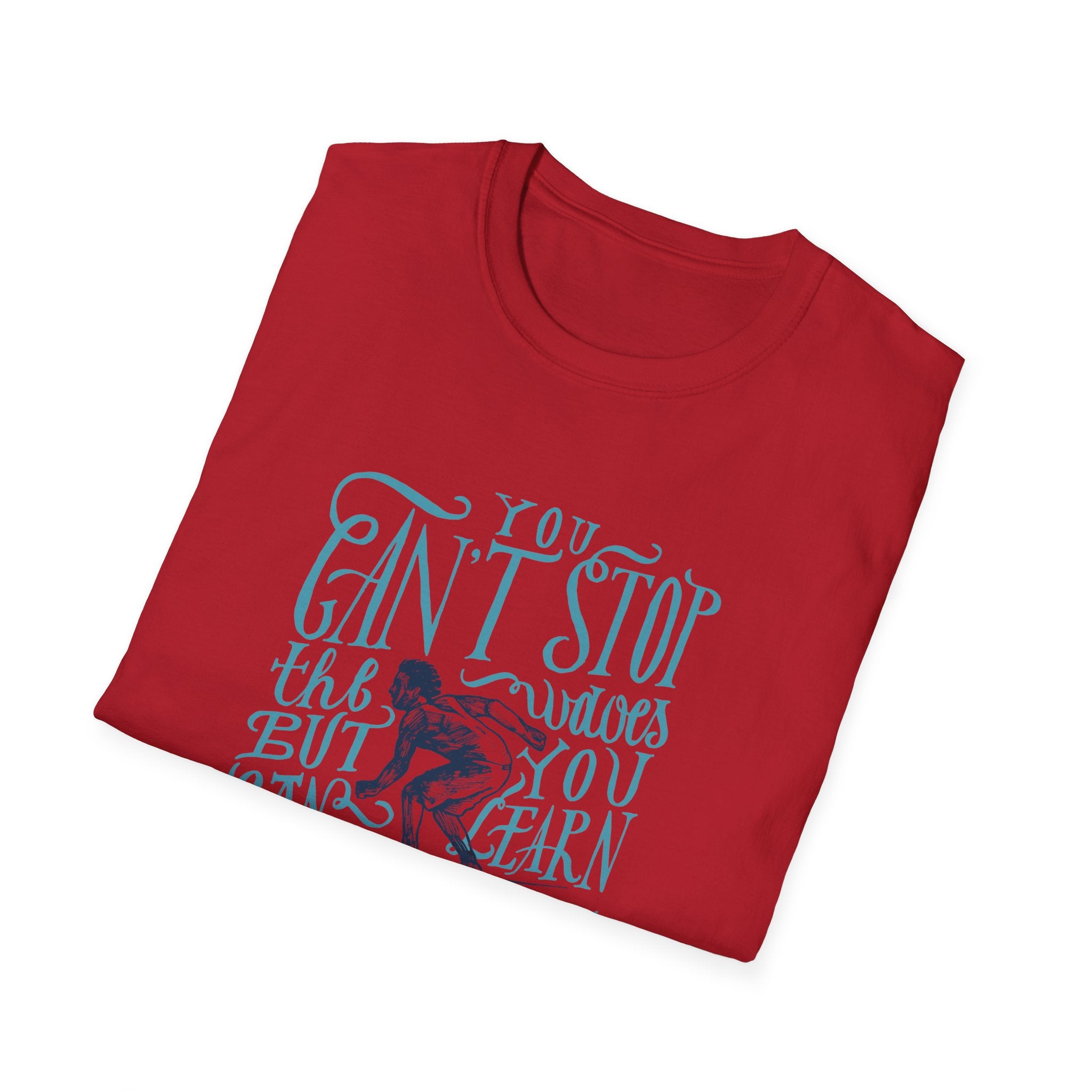 The Can't Stop Surfing T-Shirt, featuring a vintage-inspired folded design with blue lettering on a red fabric, proudly states, "You can't stop the waves, but you can learn to surf." This iconic piece perfectly captures the spirit of adventure and endless summer, making it ideal for any surfing enthusiast.