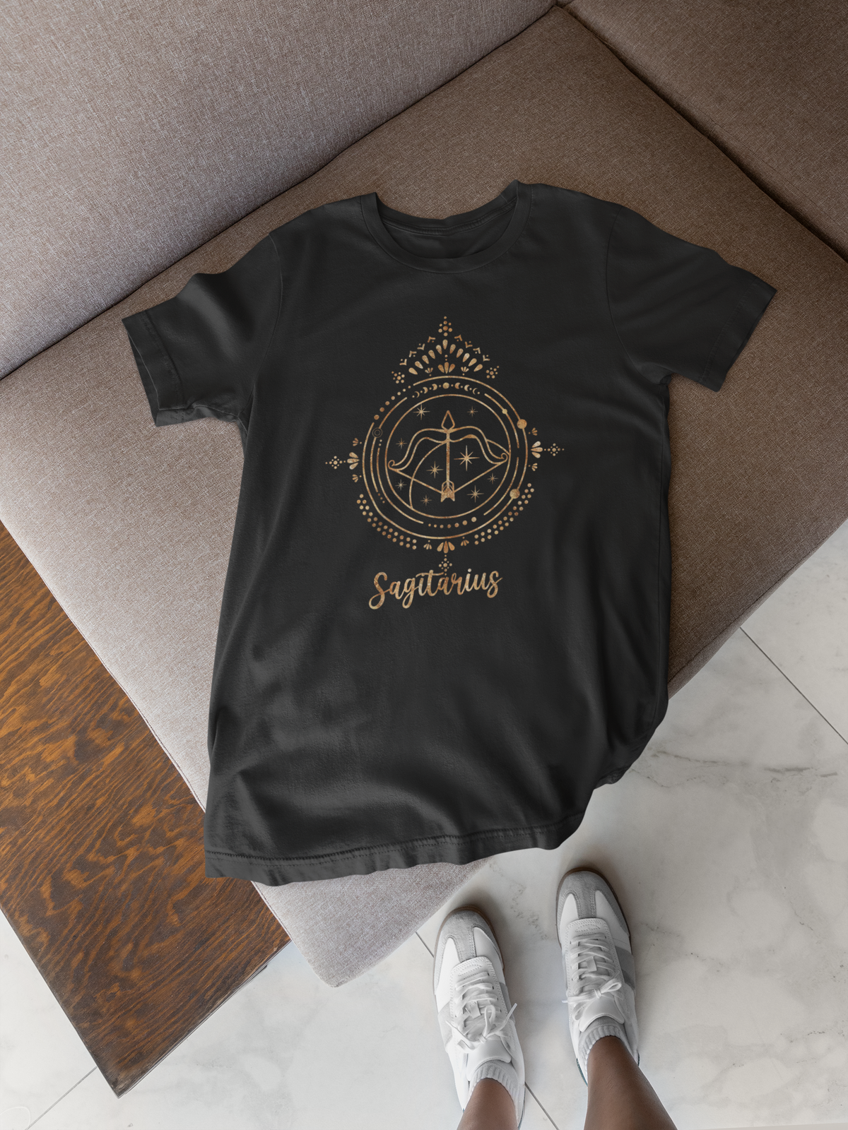 Sagittarius zodiac T-shirt in black, flat lay on a tile floor, funny gift for astrology lovers