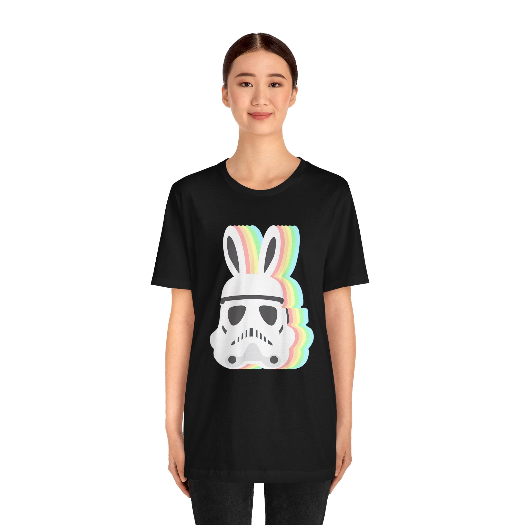 A young woman wearing a black tee featuring the Easter Stormtrooper Bunny design that combines a stormtrooper helmet with colorful bunny ears.