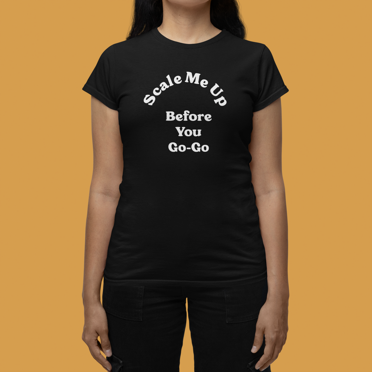 'Scale Me Up Before You Go-Go' women's t-shirt in black, woman wearing it on orange background, funny tech gift