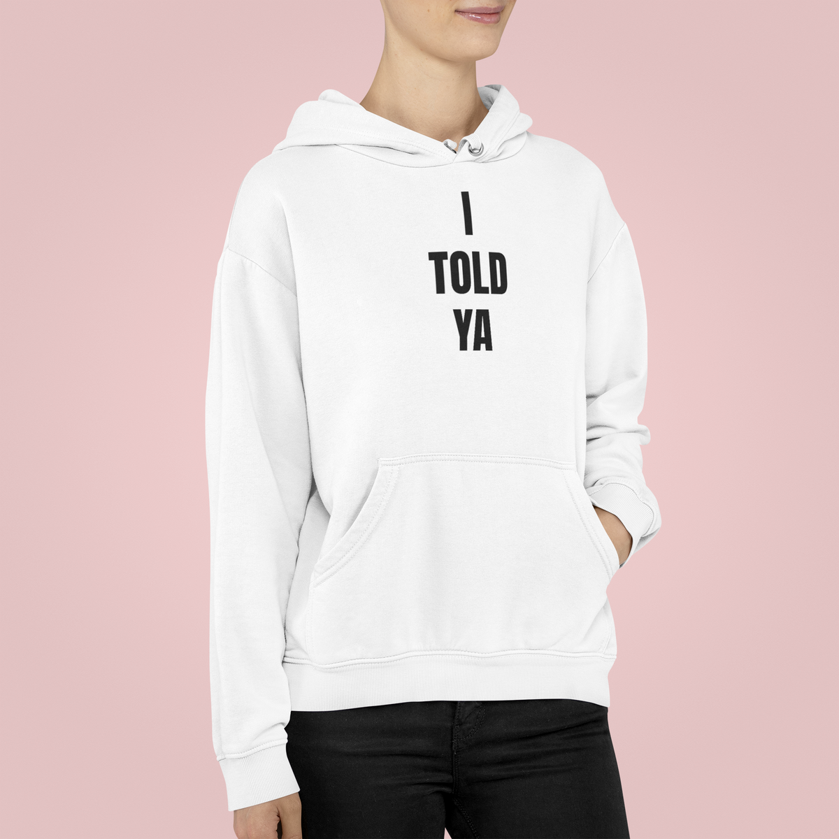 "I Told Ya" hoodie in white, woman wearing it on a pink background, funny sarcastic gift