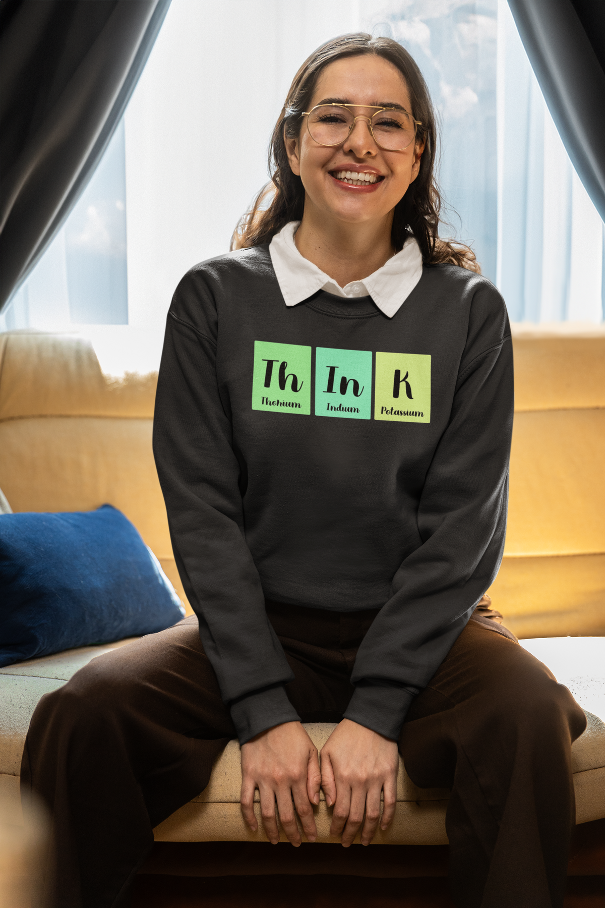 'Think' periodic table sweatshirt in black, woman wearing it seated indoors, funny science pun gift for thinkers