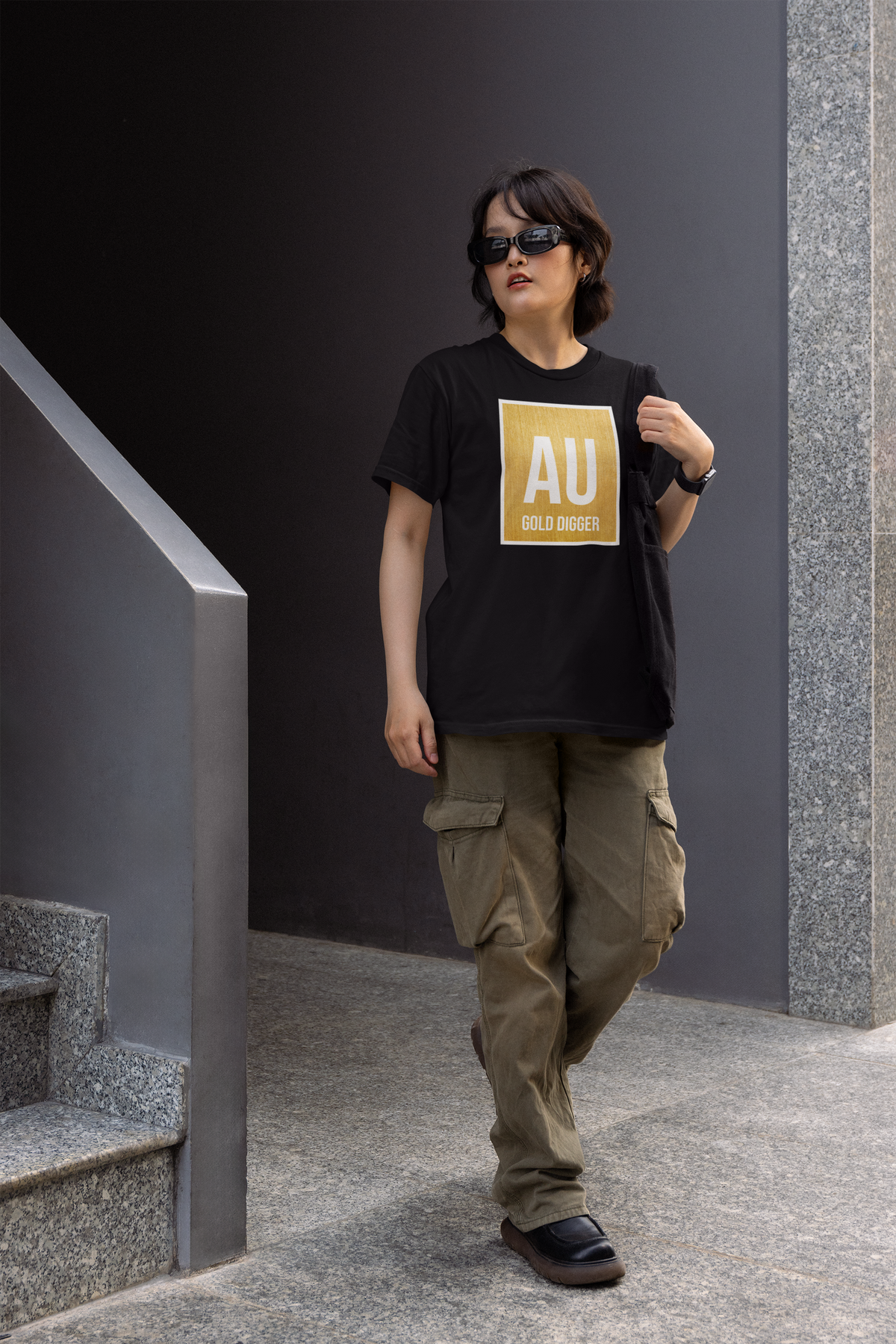 'AU Gold Digger' women's fitted t-shirt in black, person wearing it outdoors on stairs, funny chemistry pun gift