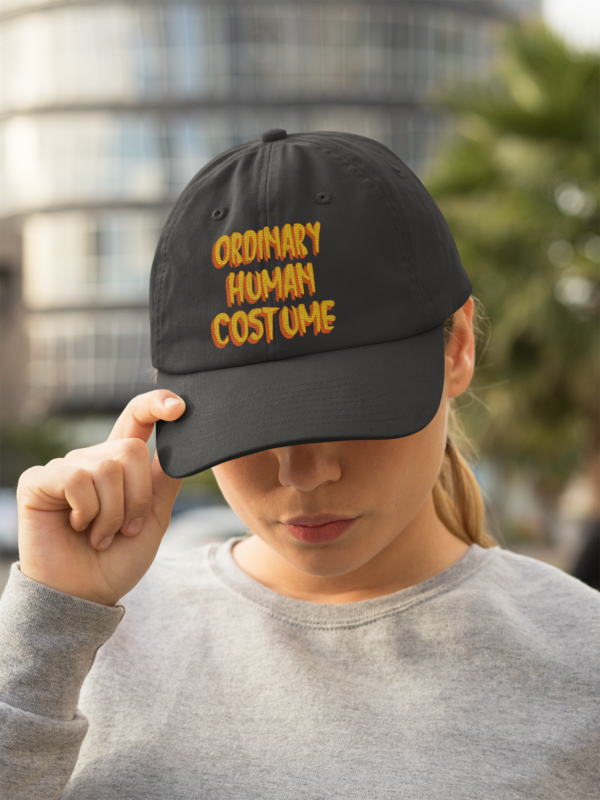 'Ordinary Human Costume' funny halloween dad hat in black, woman wearing it in city street, funny gift